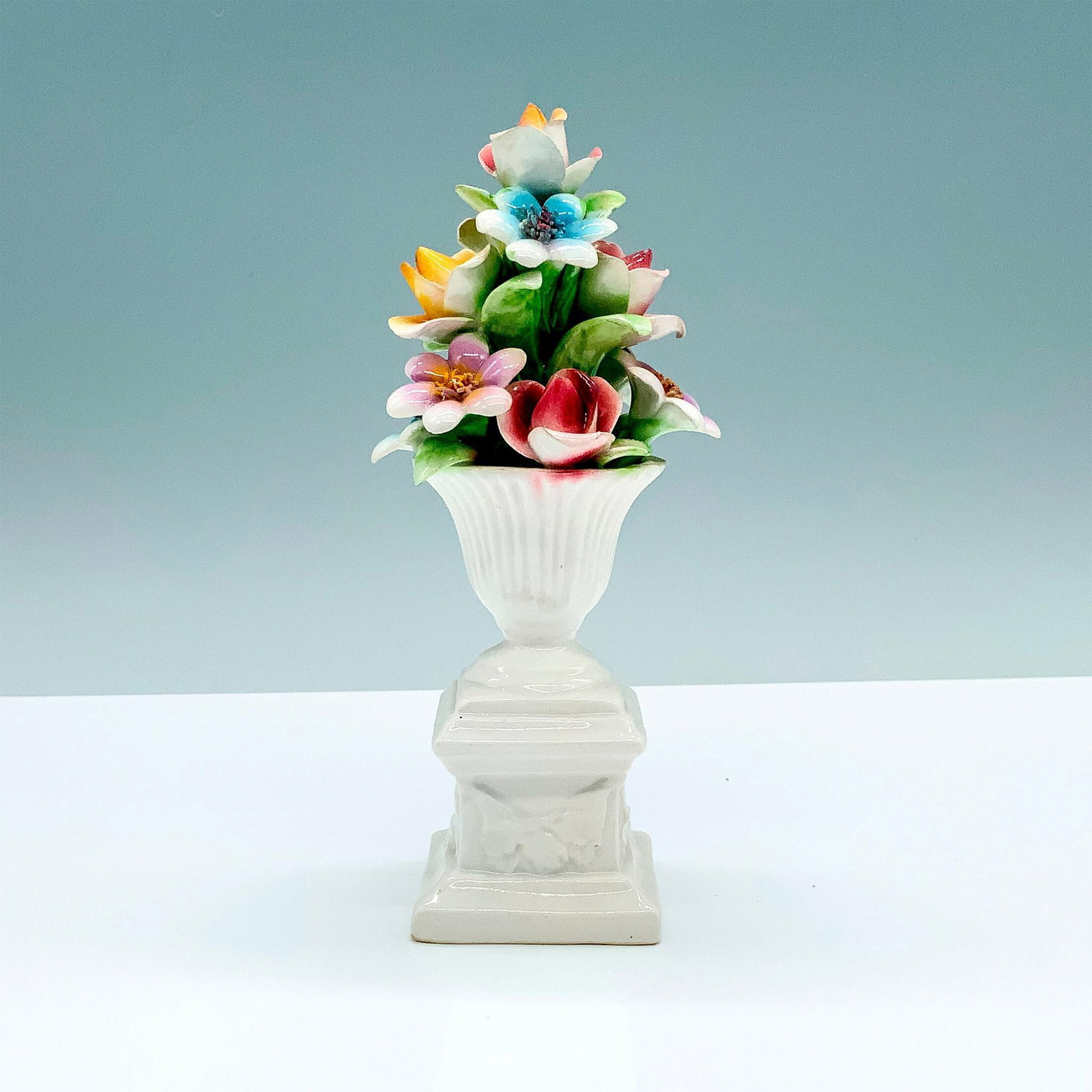 Italian Ceramic Flower Bouquet Figure: A bouquet of various flowers and placed in a white vase atop of a white square base. Marked Italy underneath. Dimensions: 3"L x 3"W x 7"H Country of Origin: Italy