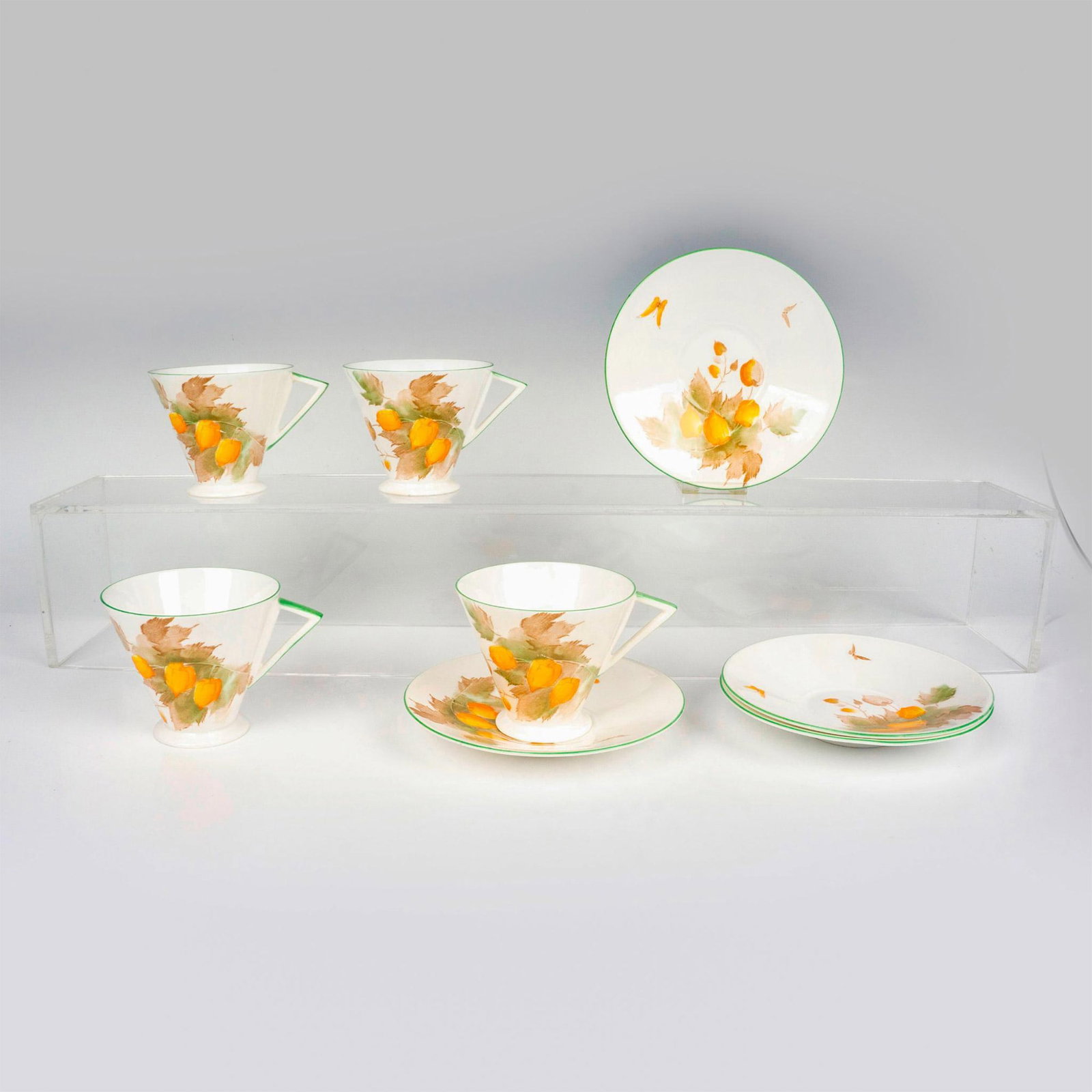 8pc Shelley China Teacups and Saucers Pattern 756533: 4 elegant white bone china teacups with matching saucers decorated with orange flowers/lanterns and green trim. Shelley backstamps. Cup: 4.5"L x 3.5"W x 3.25"H. Saucer: 1"H x 5.75"dia. Issued: 20th Ce