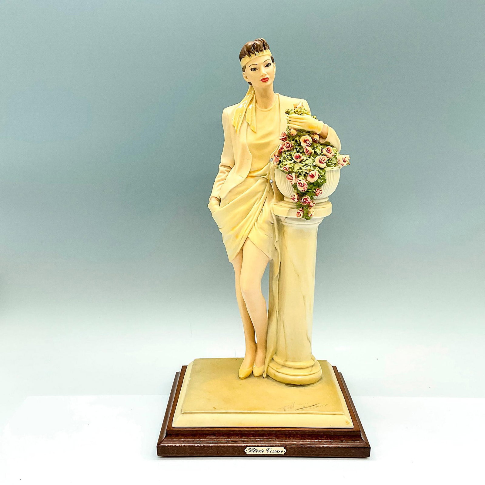 A.D.L. Vittorio Tessaro Figurine: A figure of a woman beside a pedestal with roses. Vittorio Tessaro plaque on the base. Artist signature and A.D.L. engraved on the base. Artist: Vittorio Tessaro Issued: 20th century Dimensions: 6.75"