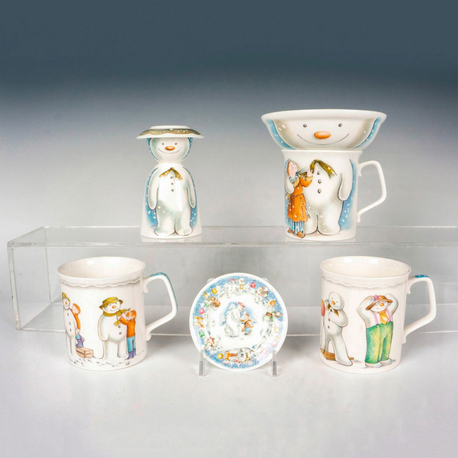 7pc Royal Doulton Snowman Gift Collection Kitchenware: Includes 3 mugs, 1 oatmeal bowl, 1 egg cup, and 2 mini side plates. Royal Doulton backstamp. Mugs measure: 3.25"L x 4.5"W x 3.75"H. Bowl measures: 5.25"W x 1.75"H. Egg cup measures: 3"W x 4.5"H. Small