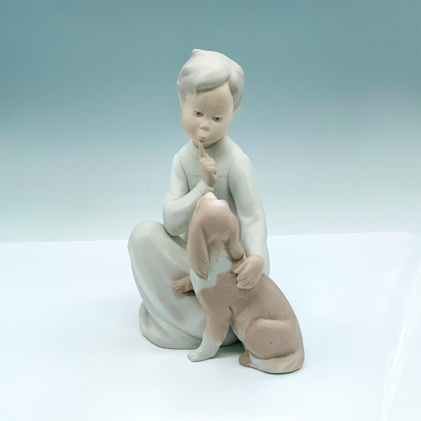 Boy With Dog 1014522 - Lladro Porcelain Figurine: Matte finish; Lladro backstamp. Artist: Vicente Martinez Issued: 1970 - 1991 Dimensions: 7.5"H Manufacturer: Lladro Country of Origin: Spain