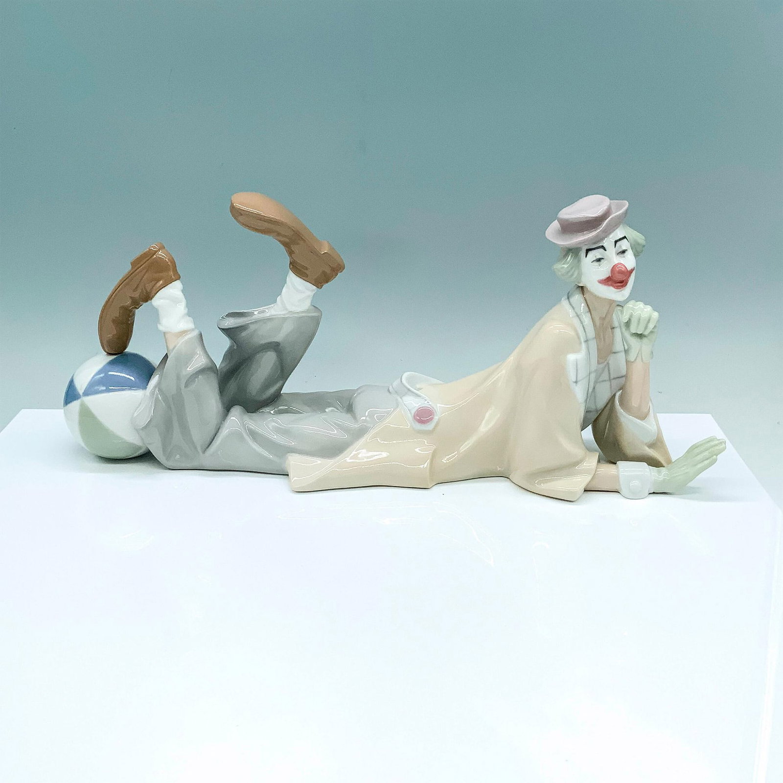 Clown 1004618 - Lladro Porcelain Figurine: Glossy finish; Lladro backstamp. Artist: Salvador Furio Issued: 1970 - 2019 Dimensions: 6.25"H x 13.75"W Manufacturer: Lladro Country of Origin: Spain