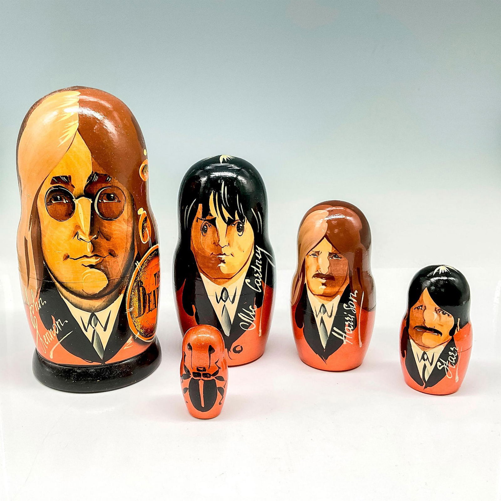 The Beatles Russian Nesting Dolls: Five wood nesting dolls of the famous British band. Each are hand painted and signed with the name of the band member. Signed on the bottom Moscow and artist's initials I.V.A in Cyrillic. Issued: 20th