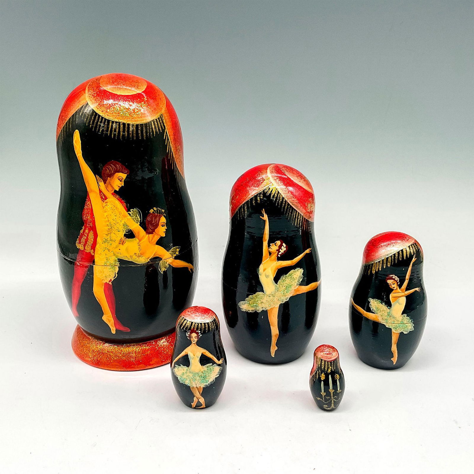 Vintage Russian Lacquered Hand Painted Nesting Dolls, Ballet: Black lacquer with red and gold toned accents and ballet performers. 5 tiered dolls. Issued: 20th century Dimensions: 7"H x 3.25" dia.
