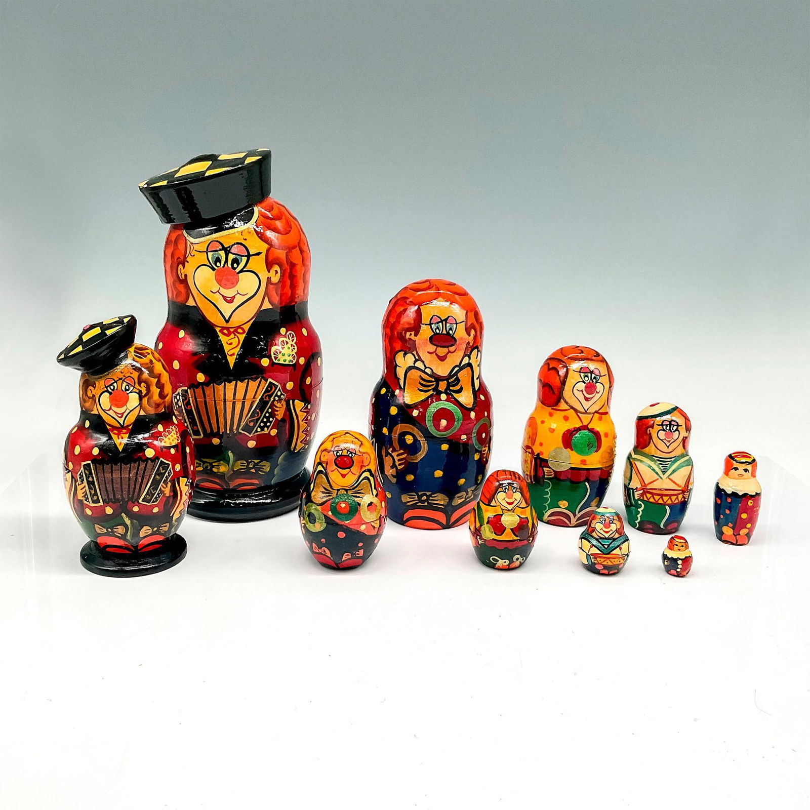 2pc Russian Lacquered Nesting Dolls, Clowns: Includes 2 hand painted whimsical designed tiered dolls. Large clown has 5 tiers - 7.25"H x 3.25" dia. Small clown also has 5 tiered dolls 4.5"H x 2.25" dia. Made in Russia sticker. Issued: 20th centu