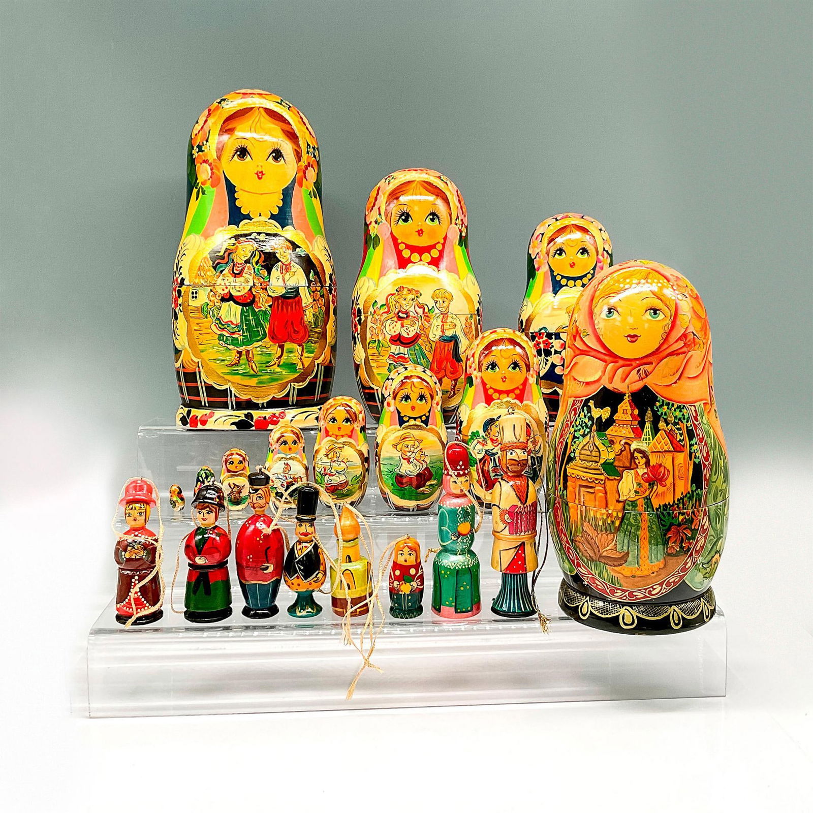 2pc Vintage Matryoshka Nesting Dolls: Includes oversized lacquered nesting dolls depicting scenes and floral designs throughout on 10. Second doll has beautiful scenes on the exterior and contains 8 Russian styled ornaments. Largest piece