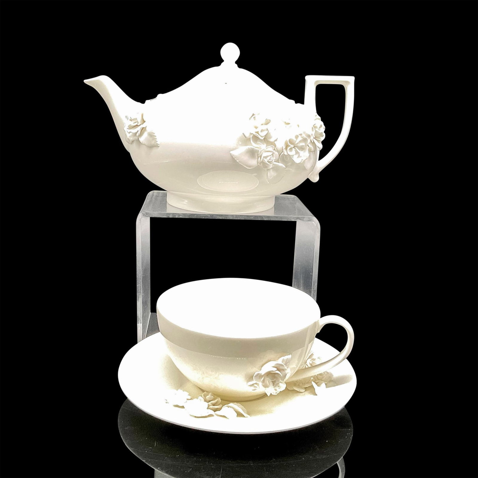 3pc Wedgwood Bone China Tea Service, Petal: Glossy finish over simple, beautiful design of raised flowers on teapot (9"L x 7"W x 6"H), cup (5.5"L x 5"W x 2.5"H) and saucer (1"H x 7" dia.). Wedgwood backstamp. Issued: 20th Manufacturer: Wedgwood