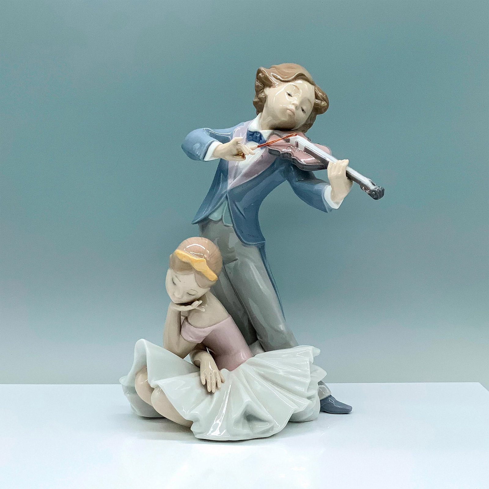 Captivating Melody 1006988 - Lladro Porcelain Figurine: Glossy finish; Lladro backstamp. Artist: Francisco Polope Issued: 2004 - 2010 Dimensions: 11.25"H x 10"W Manufacturer: Lladro Country of Origin: Spain
