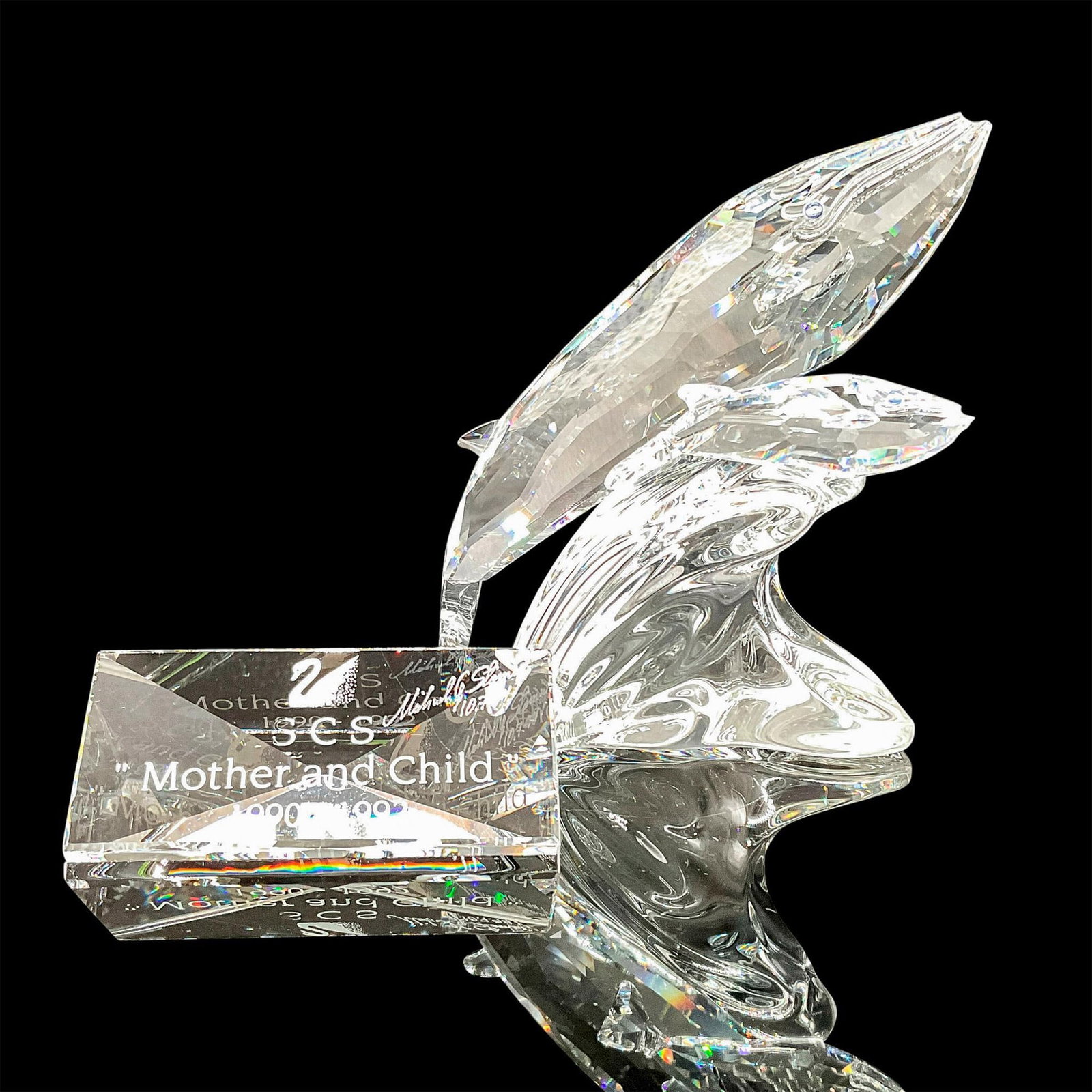 2pc Swarovski Figurine with Plaque, Care for Me, Signed: Faceted crystal figurine modeled as a blue whale and her calf riding a wave. Part of the SCS Collection. Both plaque and figurine are signed and dated by designer Michael Stamey. Original boxes includ