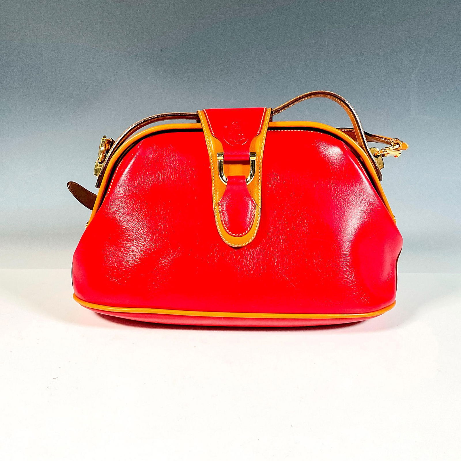 Mark Cross Red and Tan Leather Handbag: Red and tan handbag with hinged and magnetic closure; adjustable shoulder strap. Mark Cross embossed logo on the front. Includes original box, 12"L x 10.75"W x 4.75"H. Dimensions: 11"L x 4.5"W x 7"H M