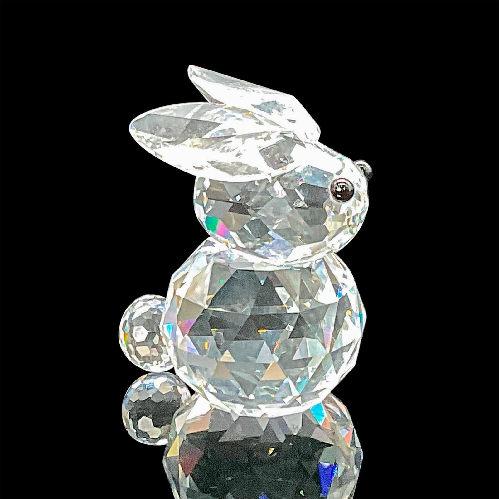 Swarovski Crystal Figurine Miniature Rabbit: This rare bunny in faceted clear crystal features jet black eyes. This variation has ears that do not lie flat on the top of his head but are more V-shaped. This one has the old block logo. This item 