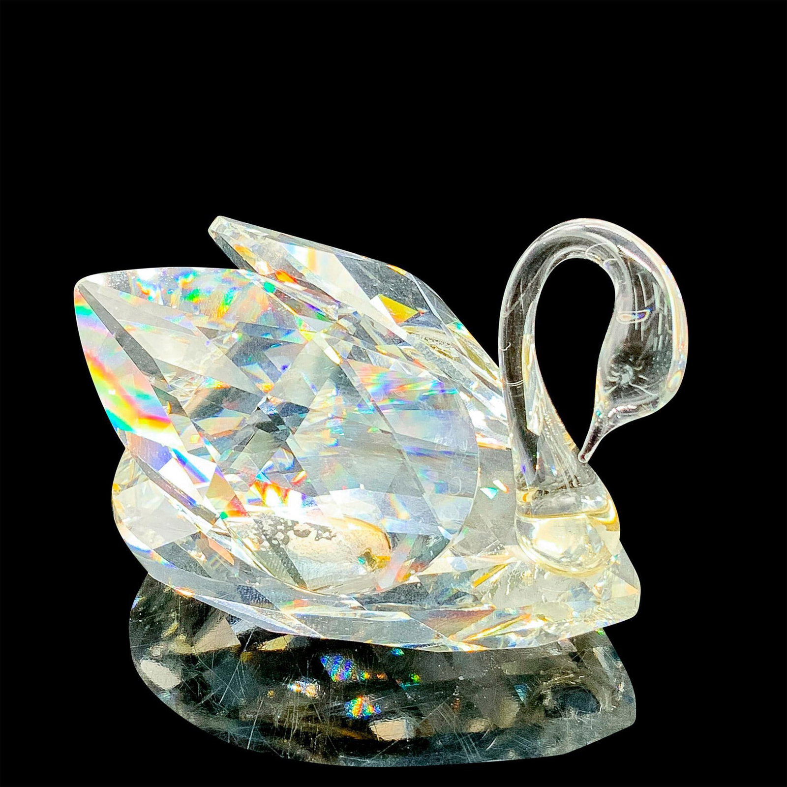 Swarovski Crystal Figurine, Swan: This retired Swarovski crystal small swan was part of the “Beauties of the Lake” theme group. Faceted clear crystal with an unfaceted neck and head. Glue holding the wings on is yellowing slig