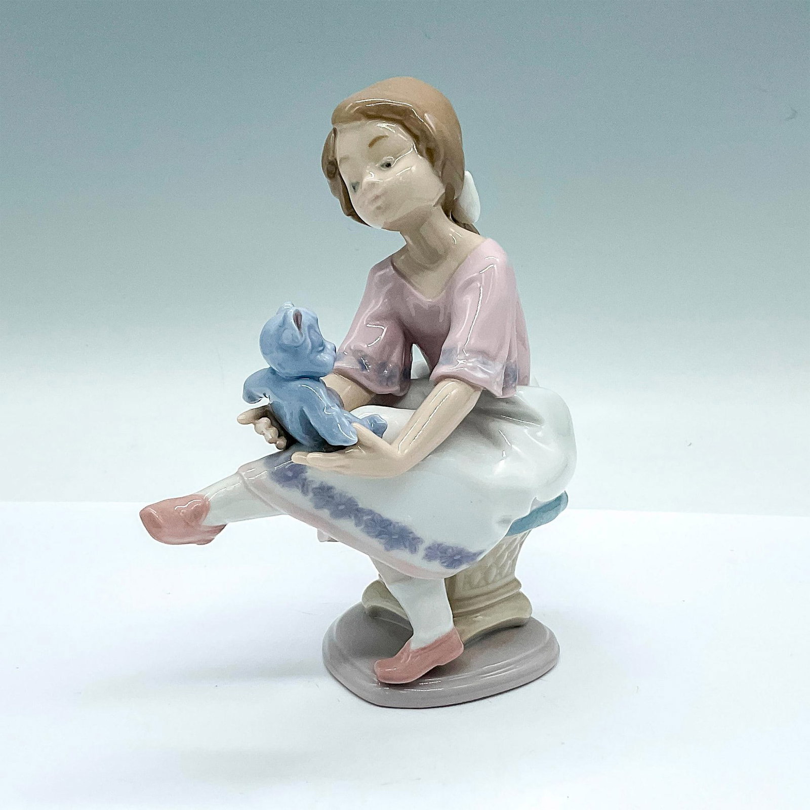 Best Friend 10047620 - Lladro Porcelain Figurine: A glossy figure of a young girl and her blue teddy bear. Lladro backstamp and 1993 Collectors Society Lladro marked on the underside. Artist: Francisco Polope Issued: 1993 Dimensions: 5.5"L x 3"W x 6.