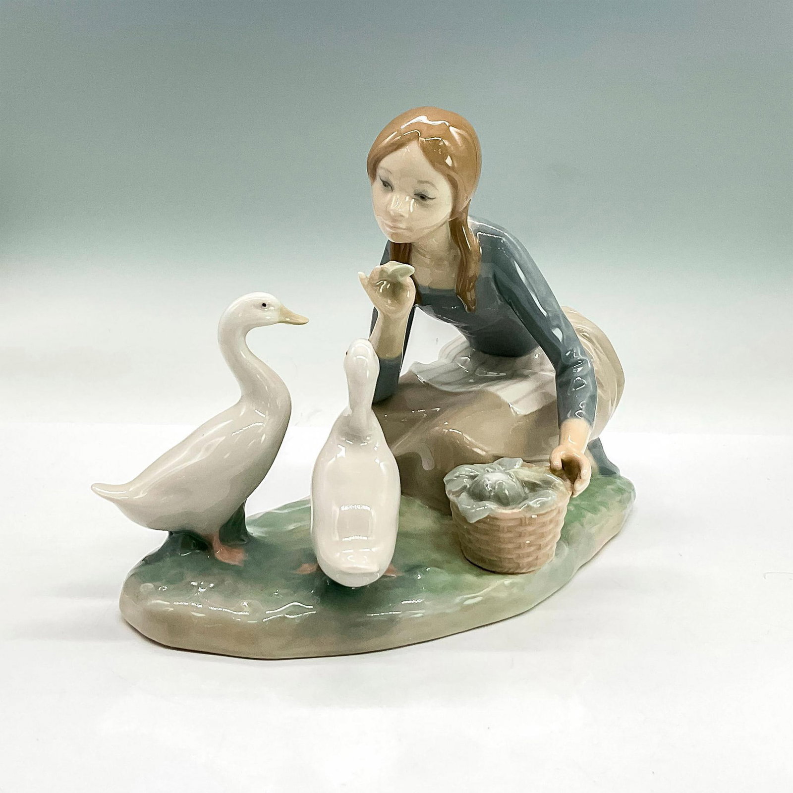 Feeding The Ducks 1004849 - Lladro Porcelain Figurine: Glossy finish; Lladro backstamp. Artist: Alfredo Ruiz Issued: 1973 - 1995 Dimensions: 6.75"H x 9.5"W Manufacturer: Lladro Country of Origin: Spain