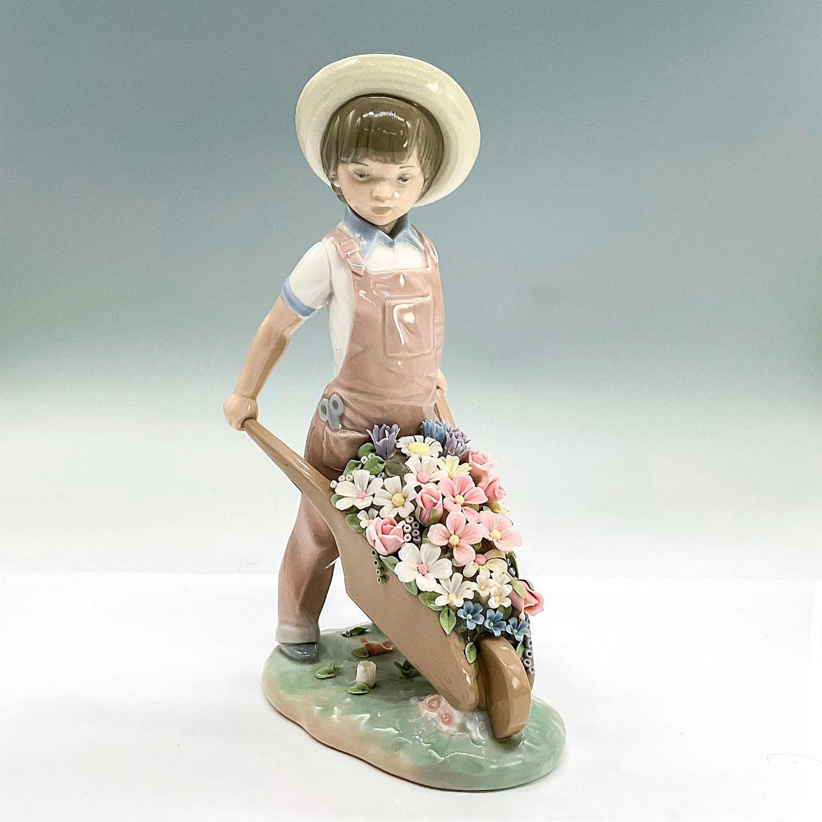 Little Gardener 1001283 - Lladro Porcelain Figurine: Glossy finish; Lladro backstamp. Artist: Francisco Catala Issued: 1974 Dimensions: 9"H x 5.5"W Manufacturer: Lladro Country of Origin: Spain