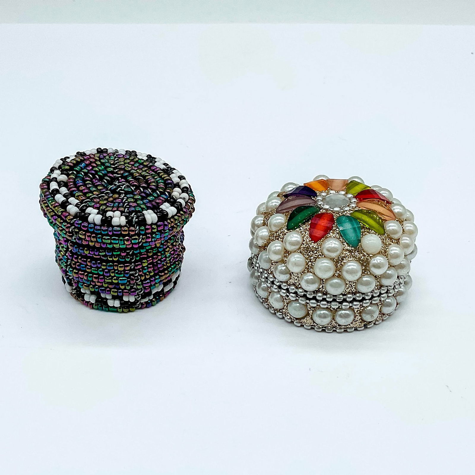 2pc Vintage Tiny Hand Made Beaded Decorative Boxes: Includes a frame box with cover, decorated in dark multicolored beads. Also includes a silver-tone metal box with cover, adorned with costume pearls and gems. Box 1: 1.75"L x 1.5"W x 1.5"H. Box 2: 2"W