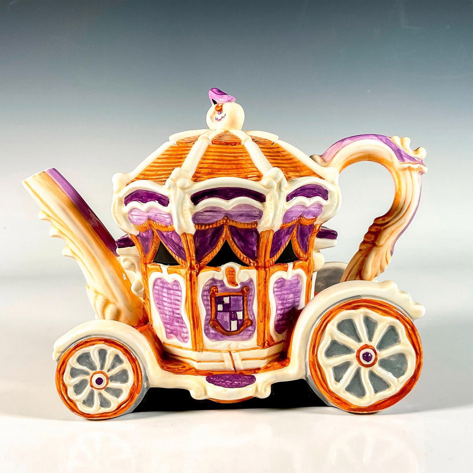 Department 56 Storybook Teapot, Cinderella Carriage: Hand painted ceramic lidded teapot in the shape of a carriage in brown and purple coloration. Department 56 backstamp. Issued: 20th c. Dimensions: 4.5"L x 8.5"W x 6.75"H Manufacturer: Department 56