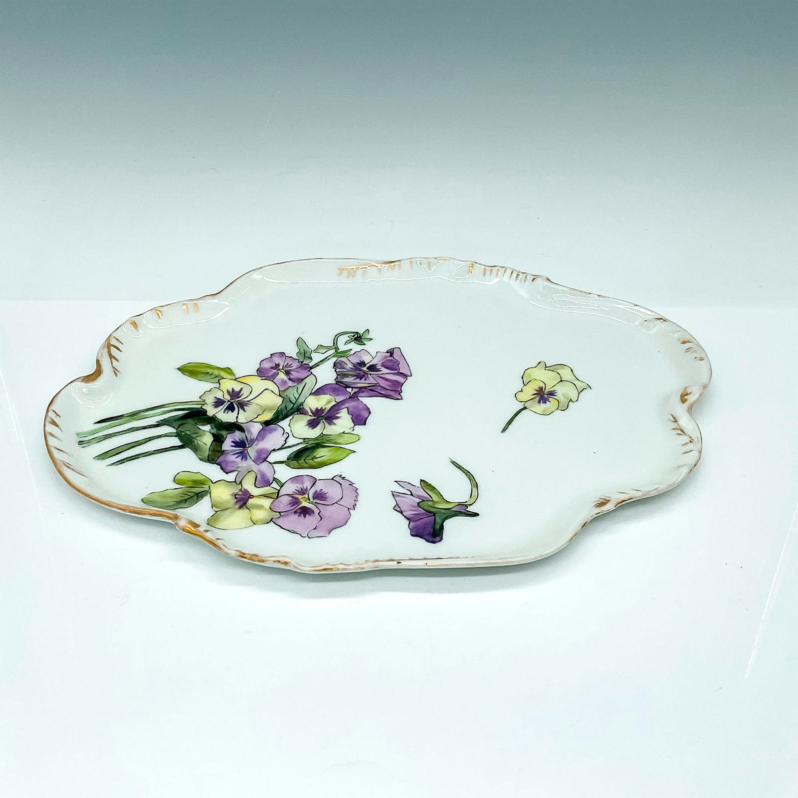 Haviland Limoges Bone China Dresser Tray, Pansies: Delightful organic shaped dresser tray hand painted with yellow and purple pansies and finished with gold. CFH/GDM France backstamp. Issued: 20th century Dimensions: 12.25"L x 8.75"W x 0.5"H Country o