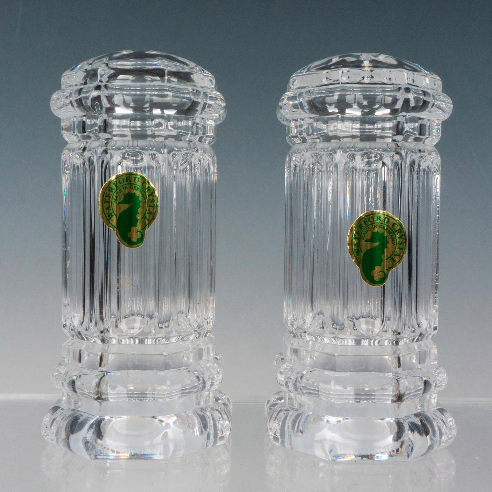 Pair of Waterford Crystal Shaker Set, Grafton Street: Clear crystal salt and pepper shakers decorated with Georgian designs. Waterford factory label. Waterford etched backstamp. This item has its original box. Box measures: 6.75"L x 5.5"W x 3"H. Issued: 