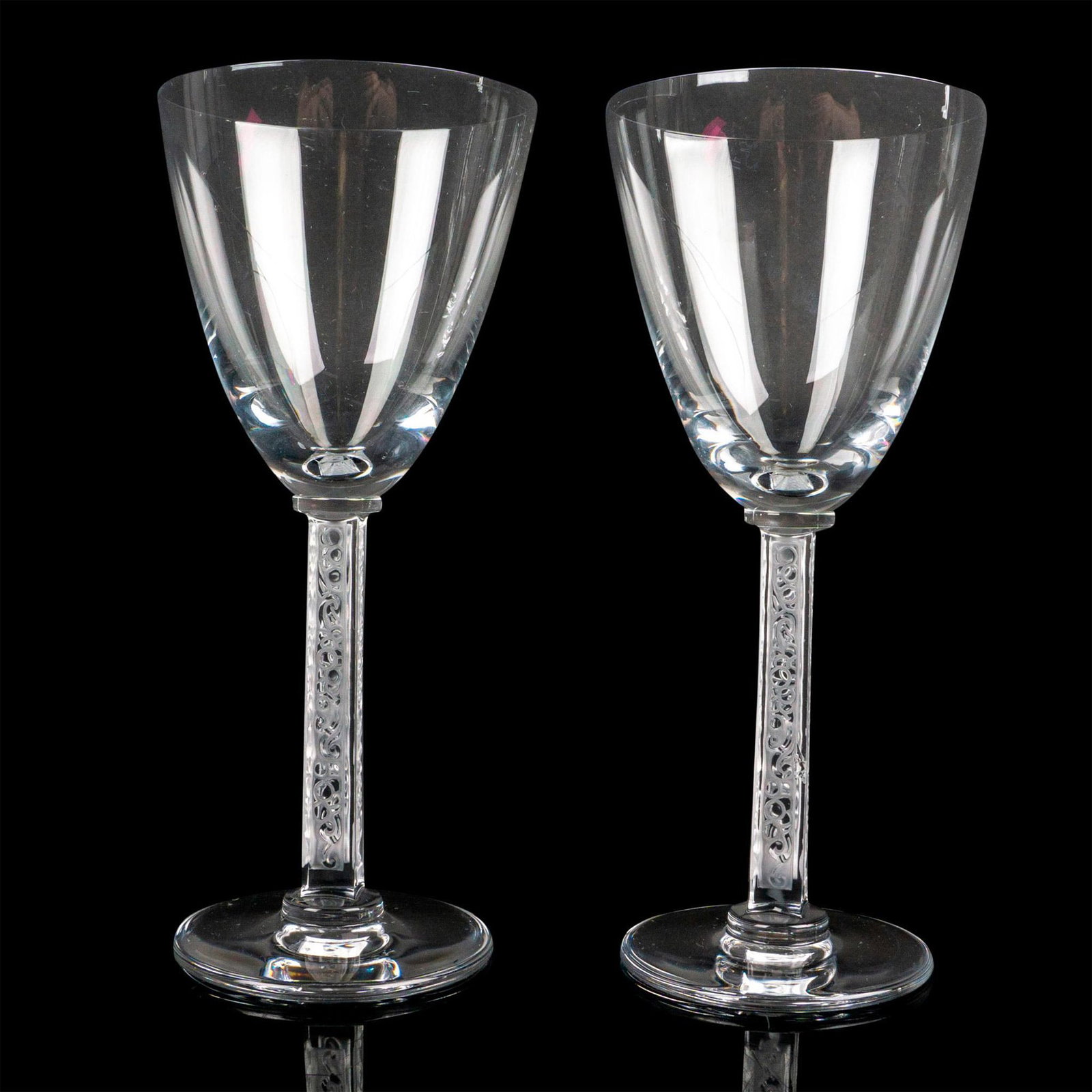 2pc Lalique Crystal Wine Glasses, Phalsbourg: Two stunning glasses, clear bowl, square etched stem with grapes design. Lalique France etched to bottom. Dimensions: 6.5"H x 2.75"dia Manufacturer: Lalique Country of Origin: France