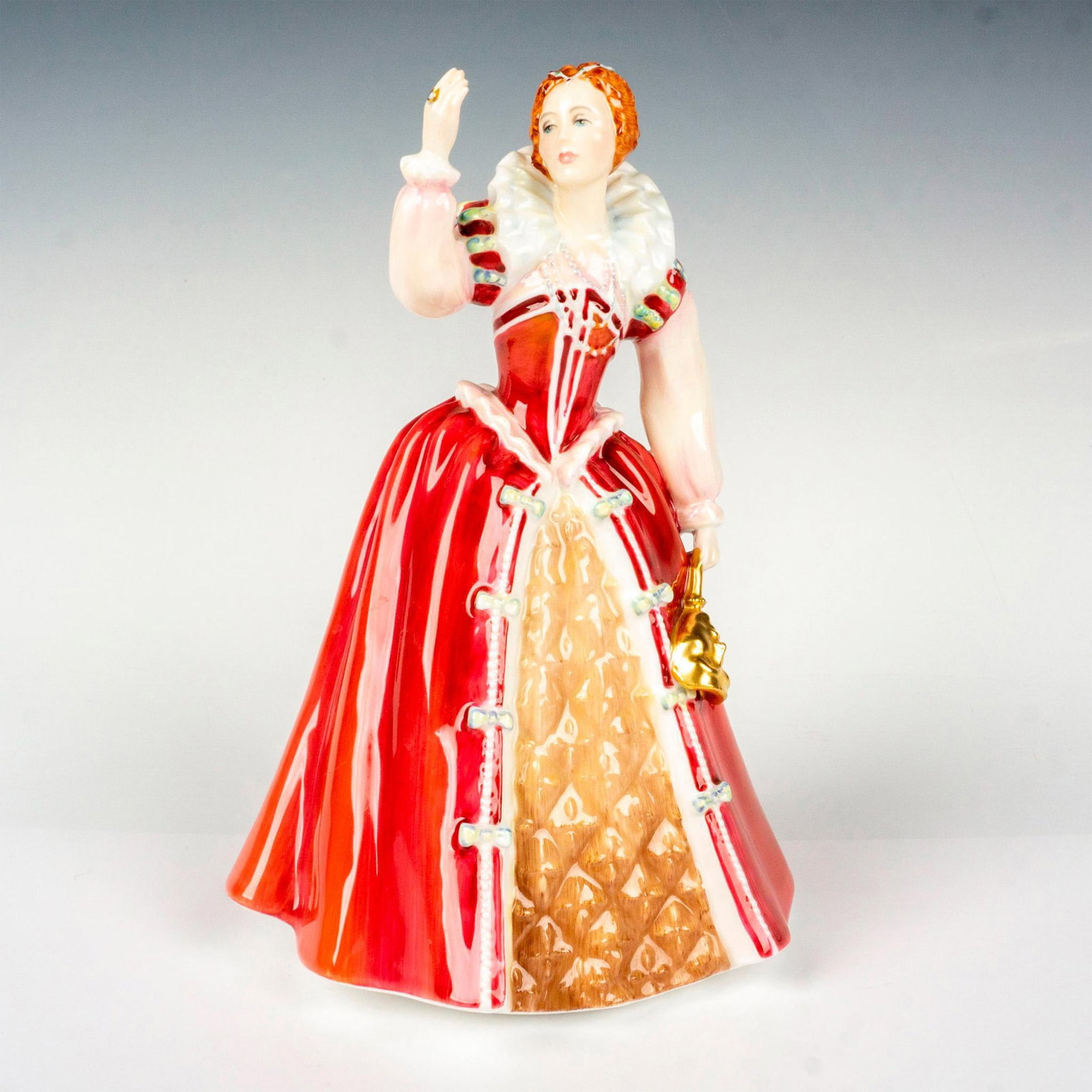 Queen Elizabeth I - HN3099 - Royal Doulton Figurine: Limited edition, Queens of the Realm series. Charming figure modeled as Queen Elizabeth I holding a gold mask, waving at the crowd. Royal Doulton backstamp. Artist: Pauline Parsons Issued: 1987 Dimens