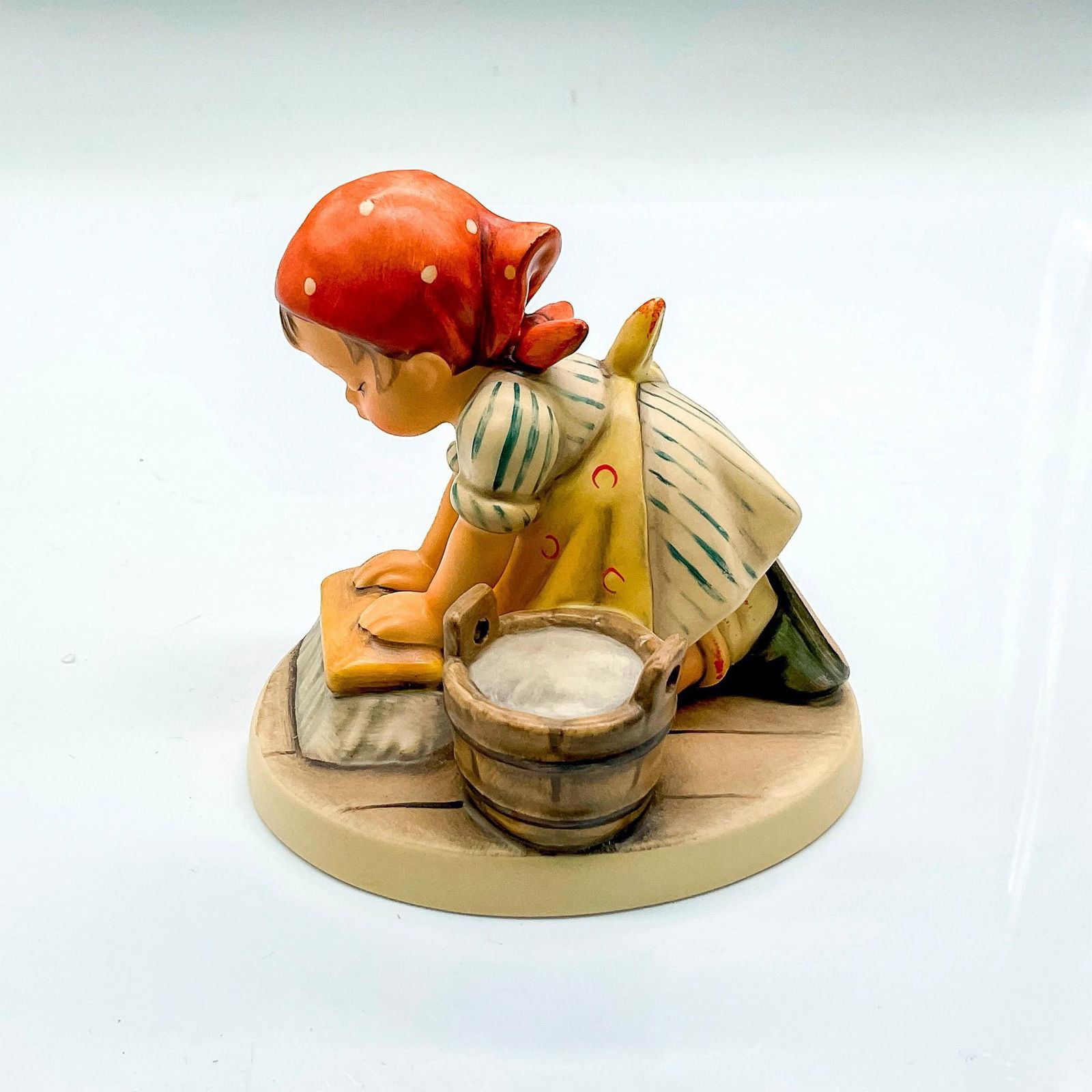 Goebel Hummel Porcelain Figurine, Big Housekeeping: Hand painted girl in red scarf with water bucket and brush. Goebel backstamp. Issued: 1998 Dimensions: 1.25"L x 3.5"W x 3.5"H Manufacturer: Goebel Hummel Country of Origin: Germany