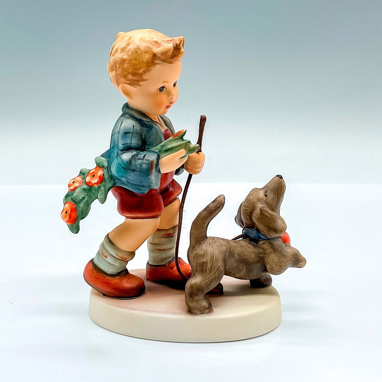 Goebel Hummel Porcelain Figurine, Sunday Stroll HUM 2237: Limited edition hand painted figure of a young boy walking his spaniel dog. Goebel backstamp. Artist: M.I. Hummel Issued: 2007 Dimensions: 4"L x 2.25"W x 4.5"H Edition Number: 2068 of 5000 Manufacture