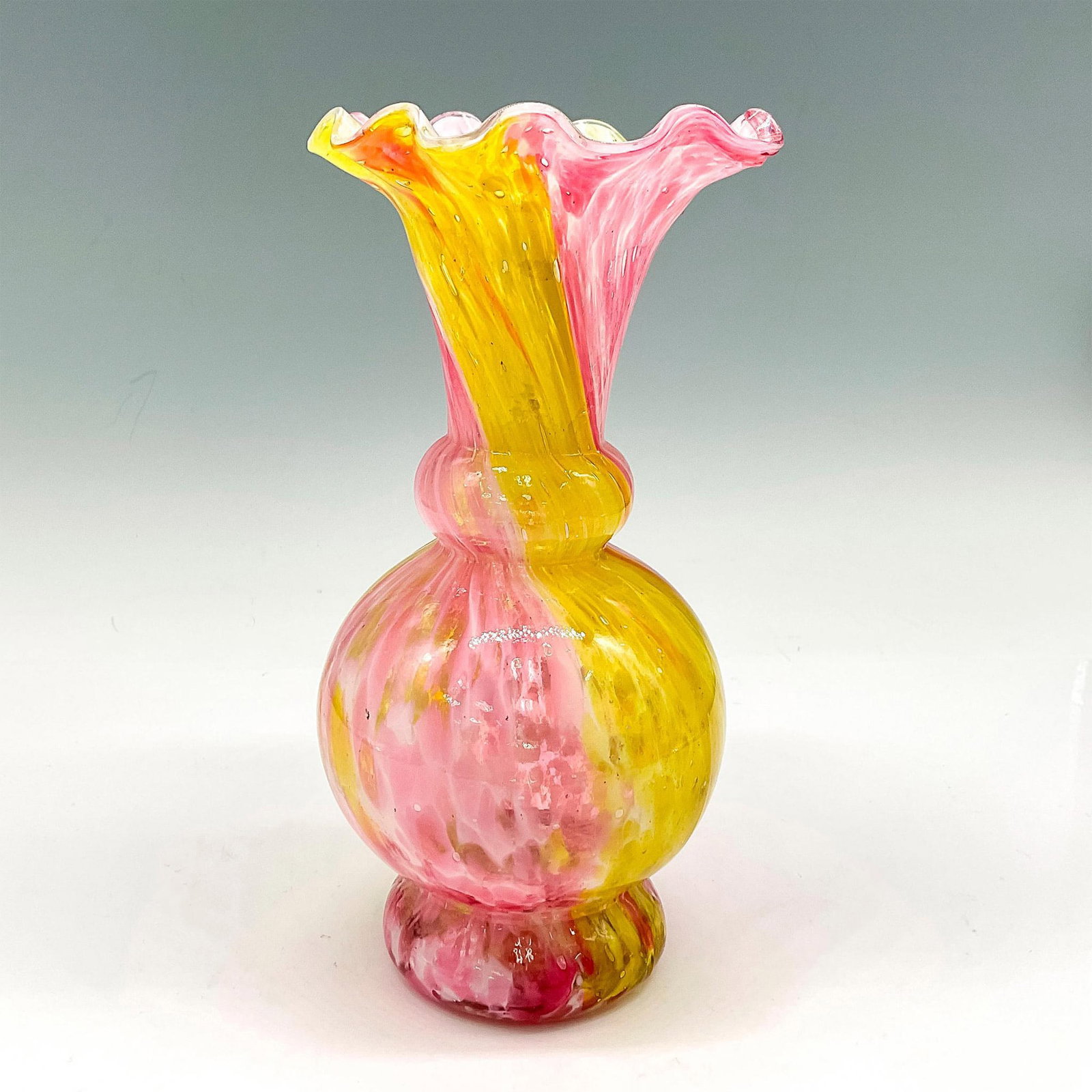 Vintage Art Glass Canary and Cranberry Speckled Vase: Designed with ruffled edge rim this vase combines two colors in a speckled, swirled pattern. Issued: 20th century Dimensions: 7.75"H x 4" dia. Manufacturer: Fenton Country of Origin: United States