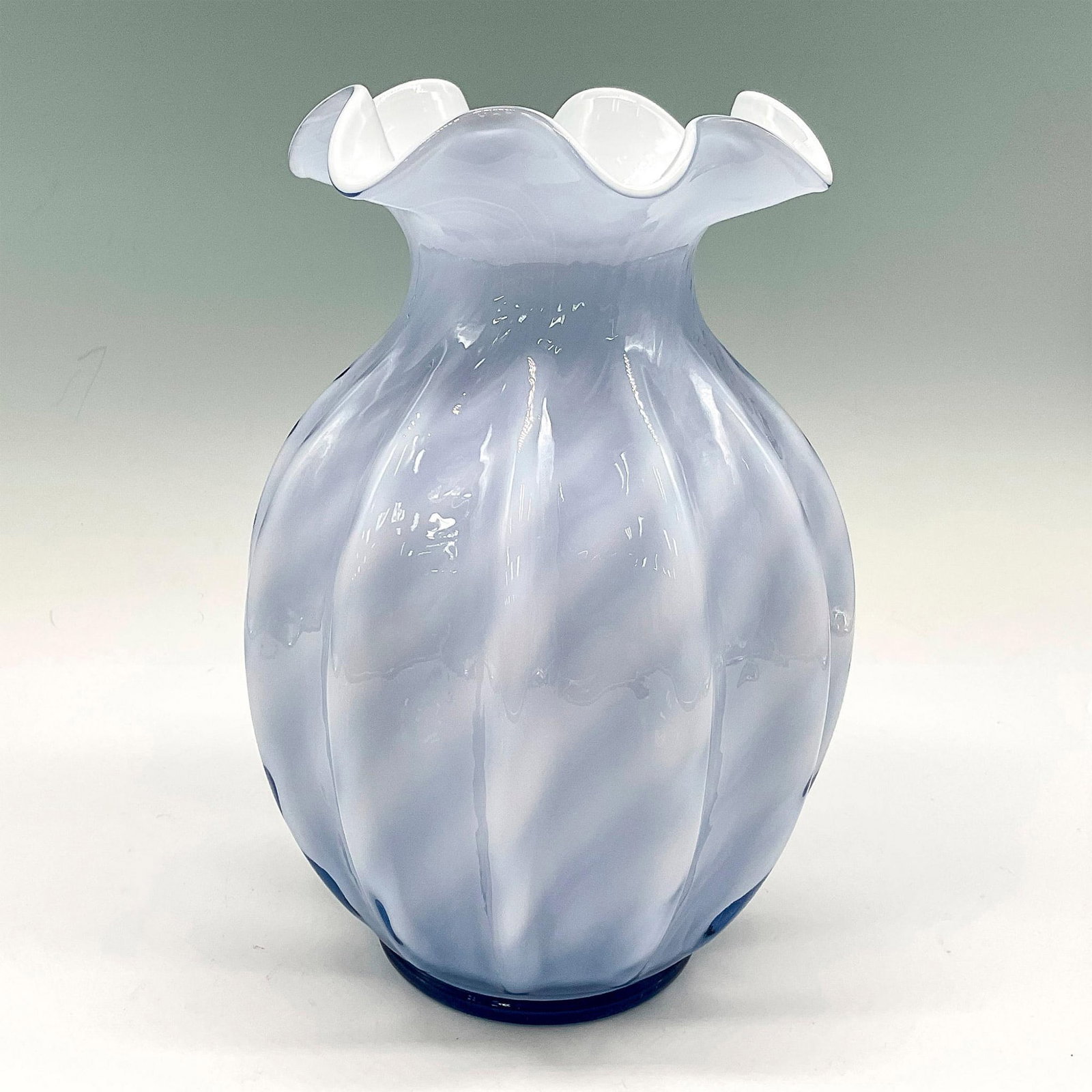Fenton Lavender White Swirl Ruffled Top Vase: Soft colors blended into a striped pattern on this ribbed vase with ruffled edge mouth. Issued: 20th century Dimensions: 7.5"H x 5" dia. Manufacturer: Fenton Country of Origin: United States
