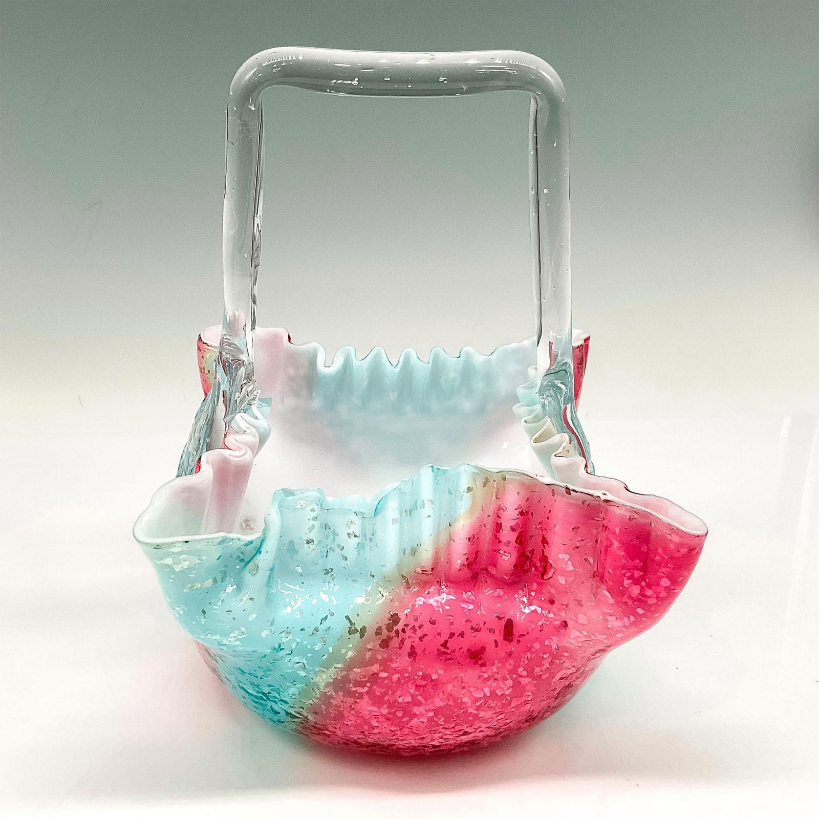 Vintage Art Glass Iridescent Basket: Square, crimped edge basket with clear smooth handle, colored in paneled, dappled raspberry and blue. Issued: 20th century Dimensions: 5.5"L x 5.25"W x 7.5"H