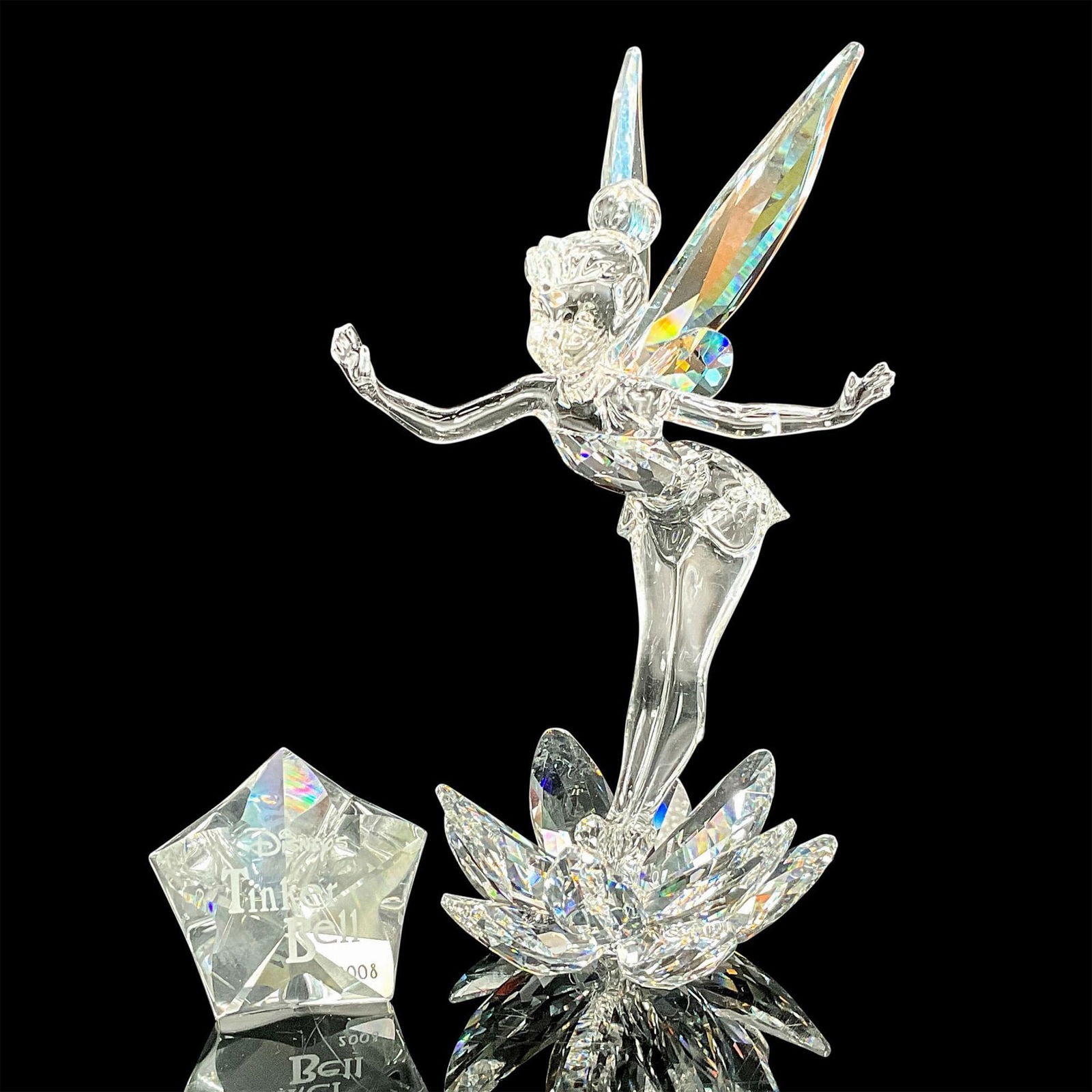 2pc Swarovski Crystal Figurine, Tinkerbell and Name Plaque: This piece is the first of a Limited Disney Series. Tinkerbell is made from clear crystal and has aurora borealis wings and comes with plaque. Swarovski etched backstamp. Figure measures: 3"L x 2.25"W