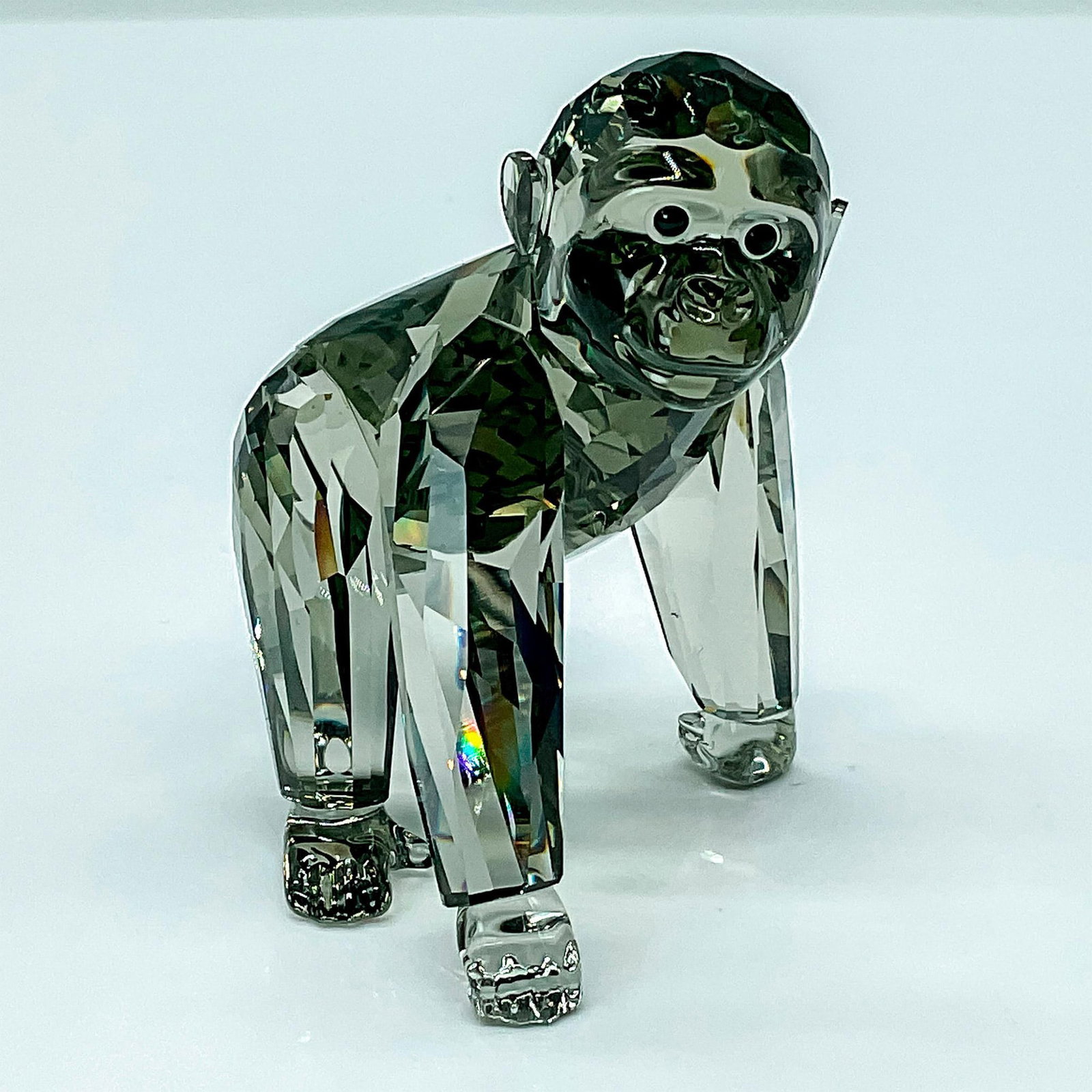 Swarovski SCS Crystal Figurine Gorilla Cub: This SCS annual edition Gorilla Cub complements the mother and child to complete the family. The little Gorilla features a fully faceted clear and Black Diamond crystal body with unfaceted hands and f
