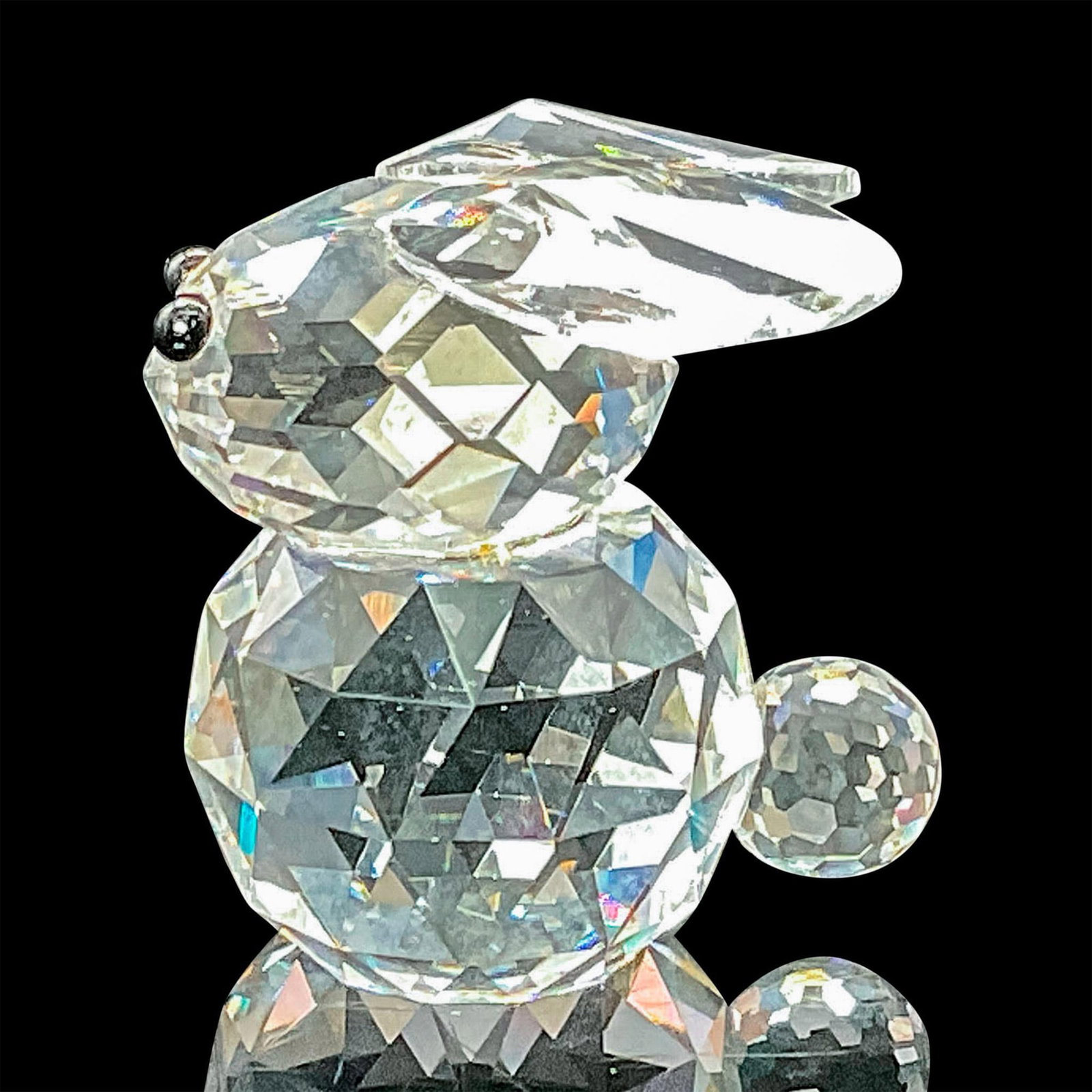 Swarovski Crystal Figurine Miniature Rabbit: This rare bunny in faceted clear crystal features jet black eyes. This variation has ears that lie flat on the top of his head. This one has the old block logo. This item has its original box which me