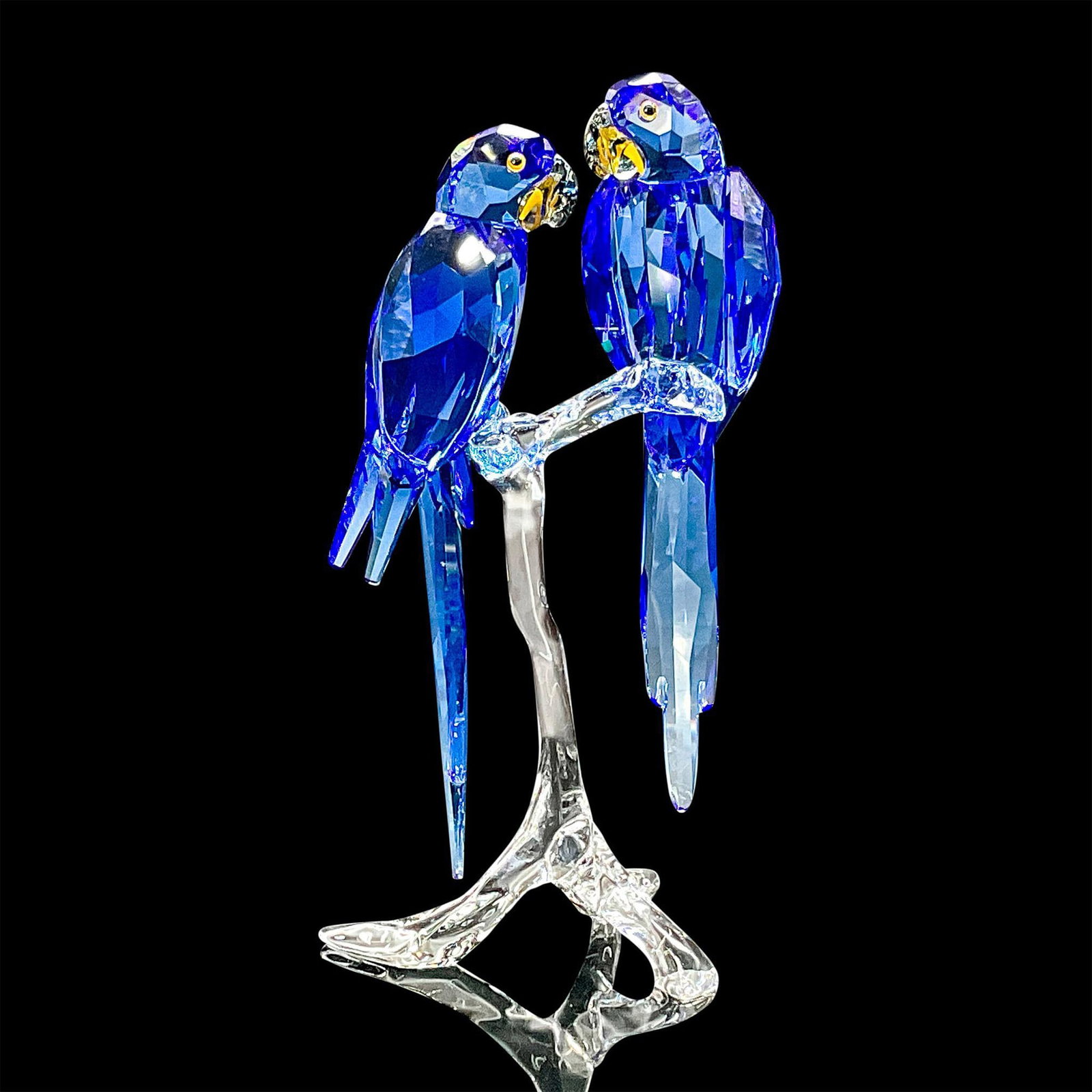 Swarovski SCS Crystal Figurine, Blue Hyacinth Macaws: This eye-catching pair of Hyacinth Macaws symbolizes togetherness and freedom. Perched on a clear crystal branch, they sparkle brilliantly in Crystal Sapphire with Black Diamond beaks and Light Topaz 