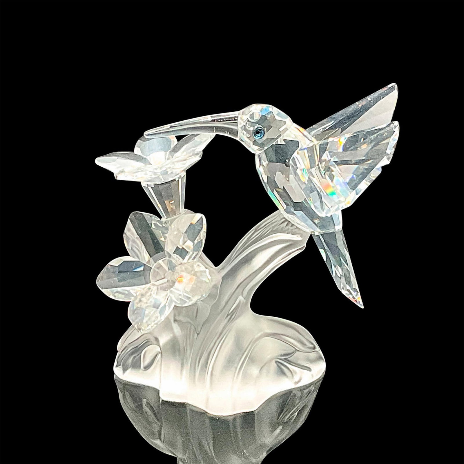 Swarovski Silver Crystal Figurine, Hummingbird 166184: This hummingbird was part of the Feathered Beauties theme. The hummingbird and flowers are made from clear crystal, eyes are black crystal, while the base is made from frosted crystal. Swarovski etche