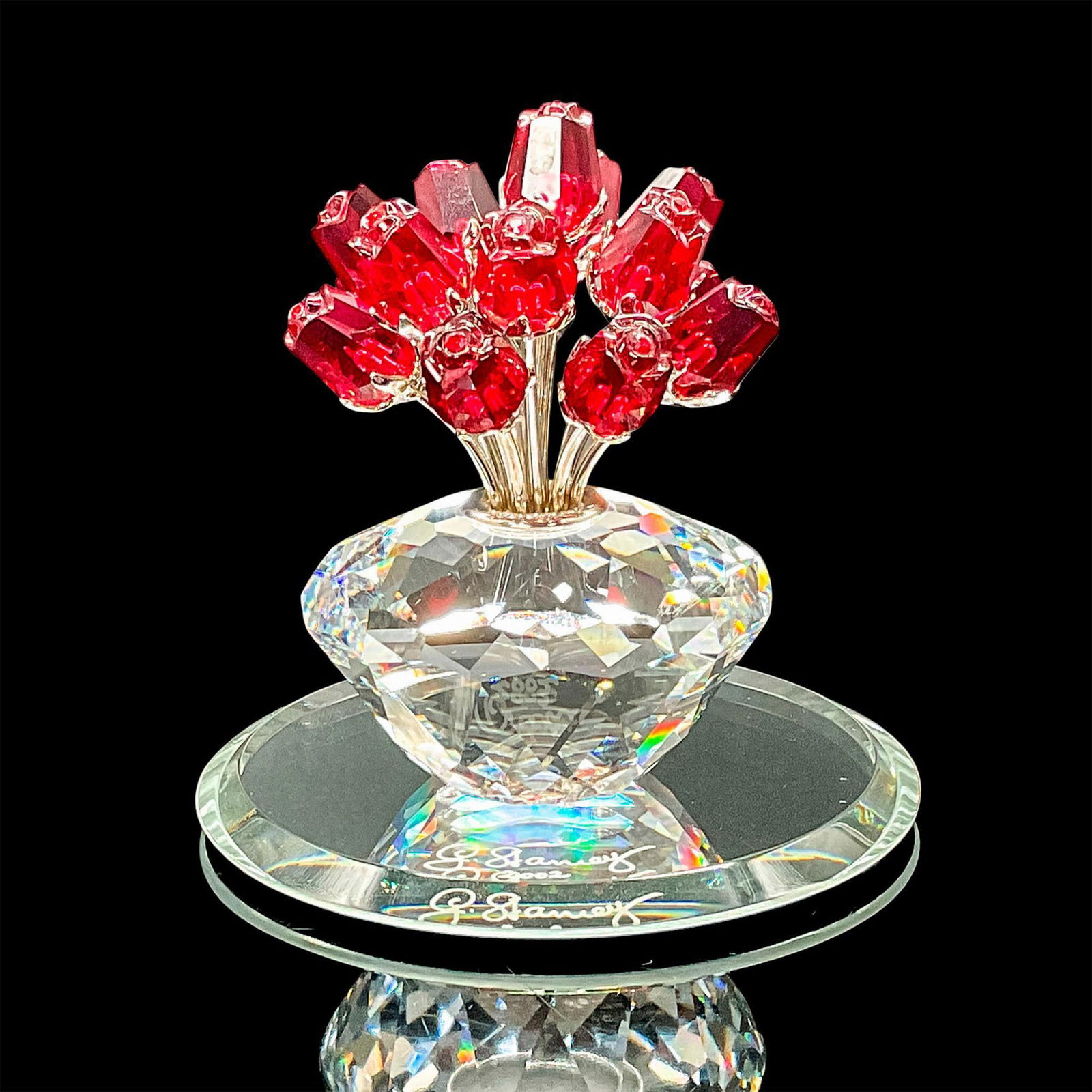 Swarovski SCS Crystal Figurine, Red Roses 15th Anniversary + Mirror Base: This limited-edition vase of 15 red roses symbolizes love, passion, and celebration. Made with clear crystal and rhodium stems, this piece was made to celebrate the 15th anniversary of the SCS. This i