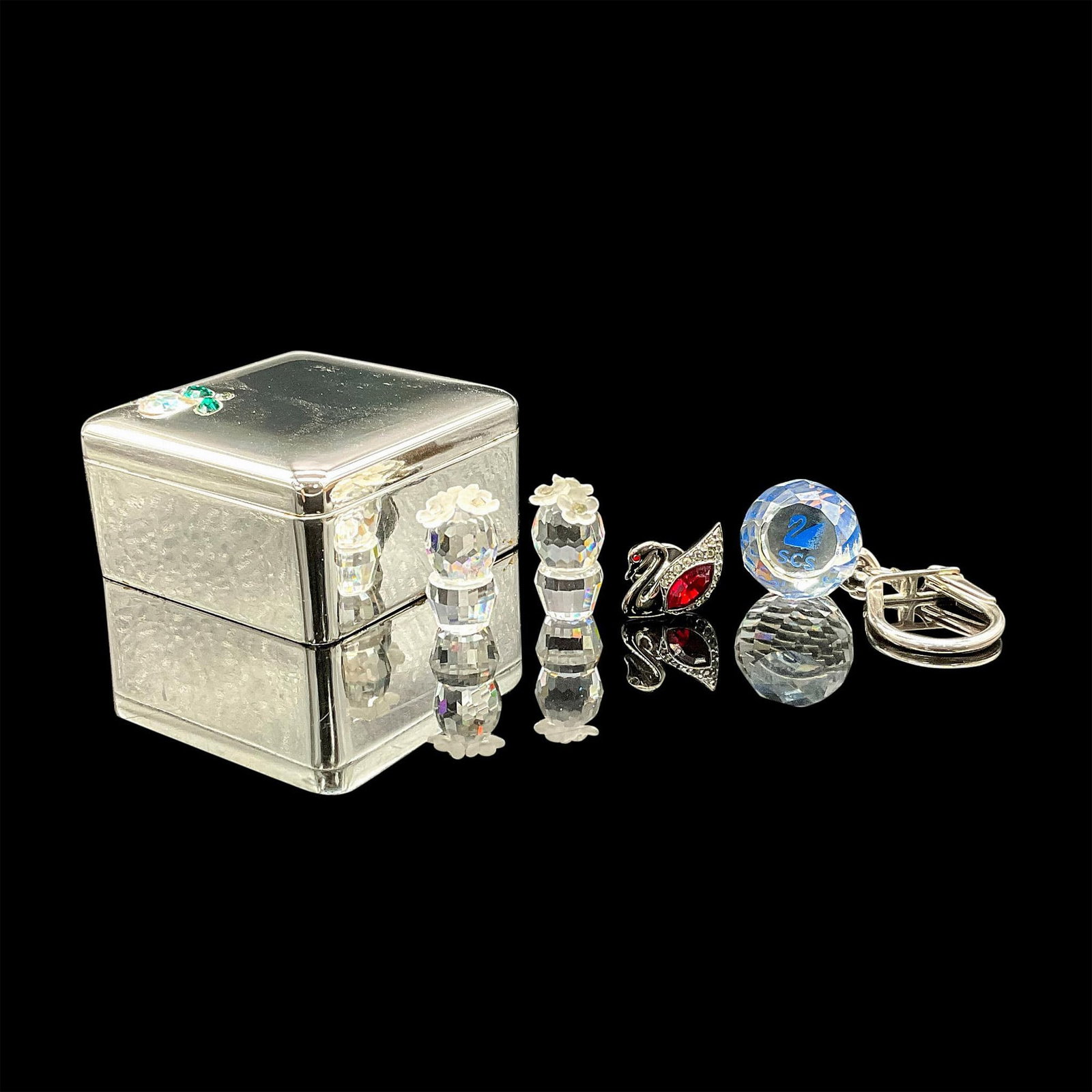 5pc Swarovski Crystal Pieces with Small Ring Box: This Swarovski grouping features a silver toned jewelry box, a SCS prism paperweight, two mini cactus figurines, and a swan lapel pin. Largest piece measures 2.25"L x 2.25"W x 1.25"H. Swarovski etched