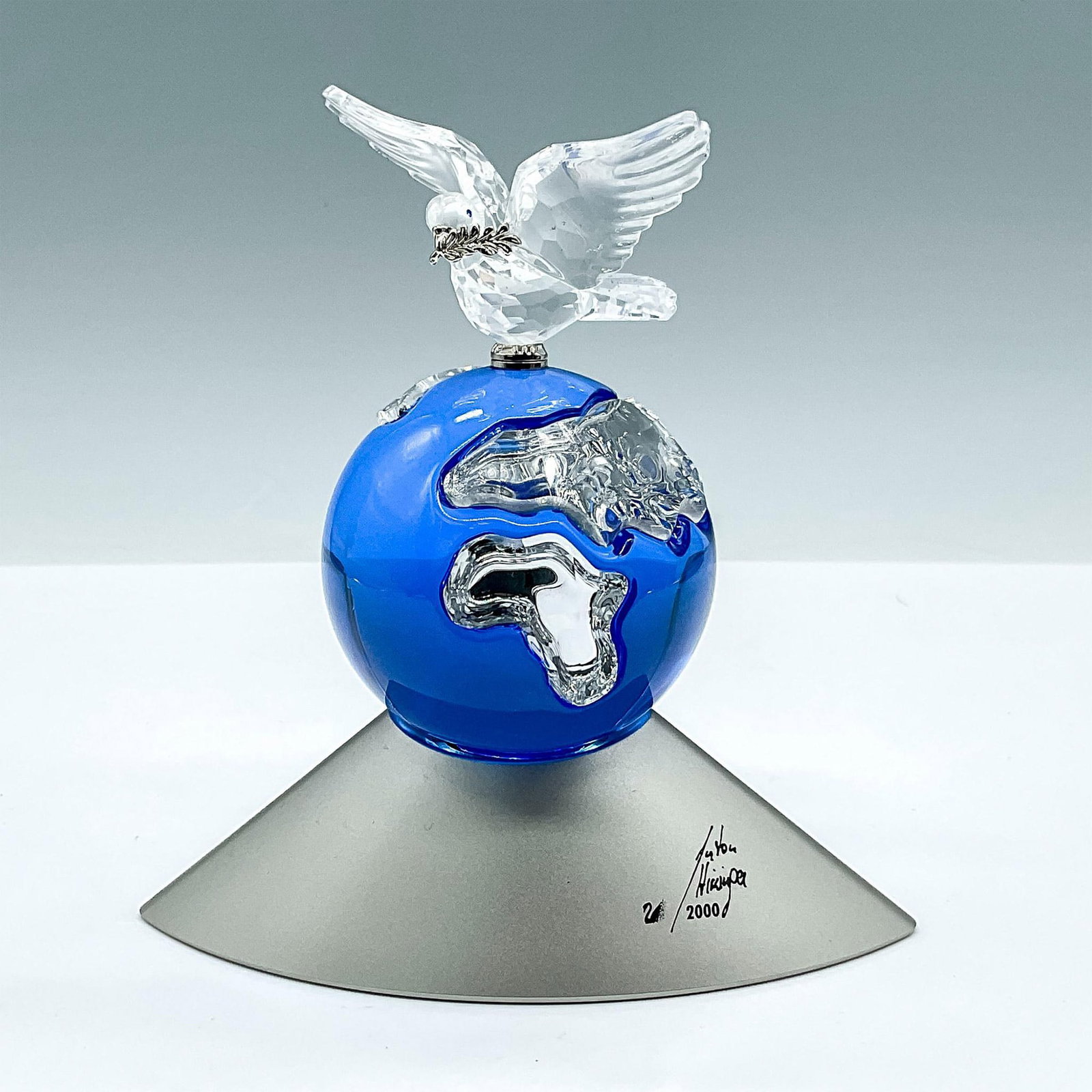 Swarovski Crystal Figurine, Millennium Edition Planet: This exquisite crystal Planet was designed to celebrate the new Millennium and features a stunning sapphire blue globe with clear crystal continents. A clear crystal dove carrying an olive branch is p