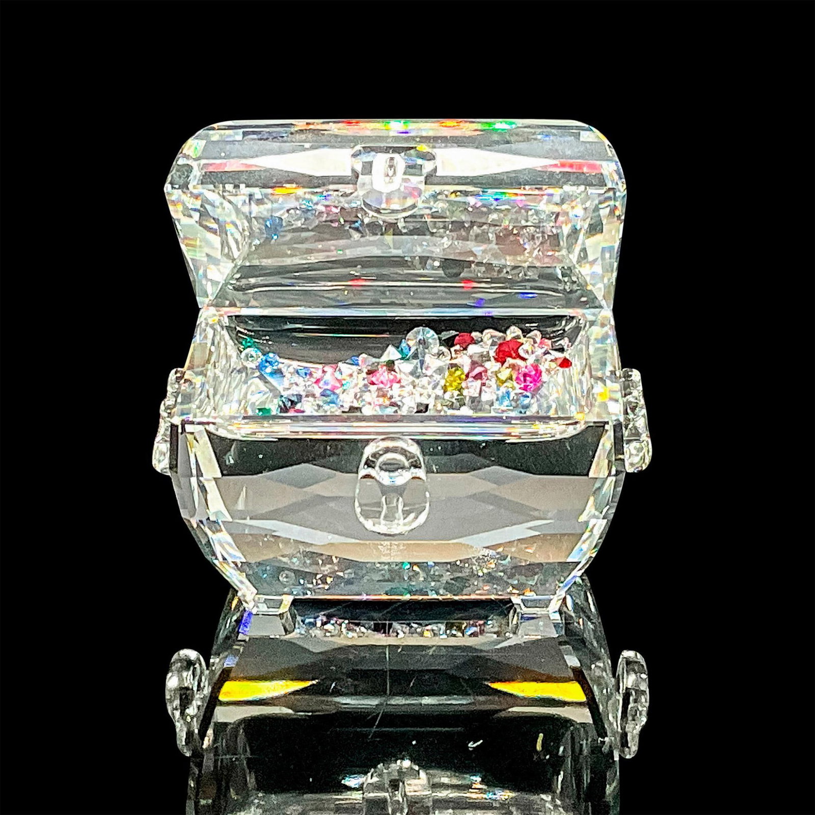 Swarovski Crystal Figurine, Treasure Chest w/Colored Stones: Lead crystal, depicting an opened with tiny colored stones. Swarovski etched backstamp. Comes in original box which is 4.5"L x 4.5"W x 2.5"H. Artist: Edith Mair Issued: 2006-2008 Dimensions: 1.75" L x
