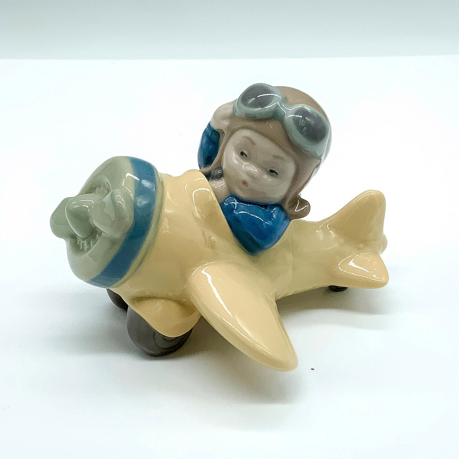 Up and Away 2001540 - Nao by Lladro Porcelain Figurine: Glossy finish; Nao backstamp. Dimensions: 4.5"L x 4.25"W x 3.75"H Manufacturer: Nao by Lladro Country of Origin: Spain