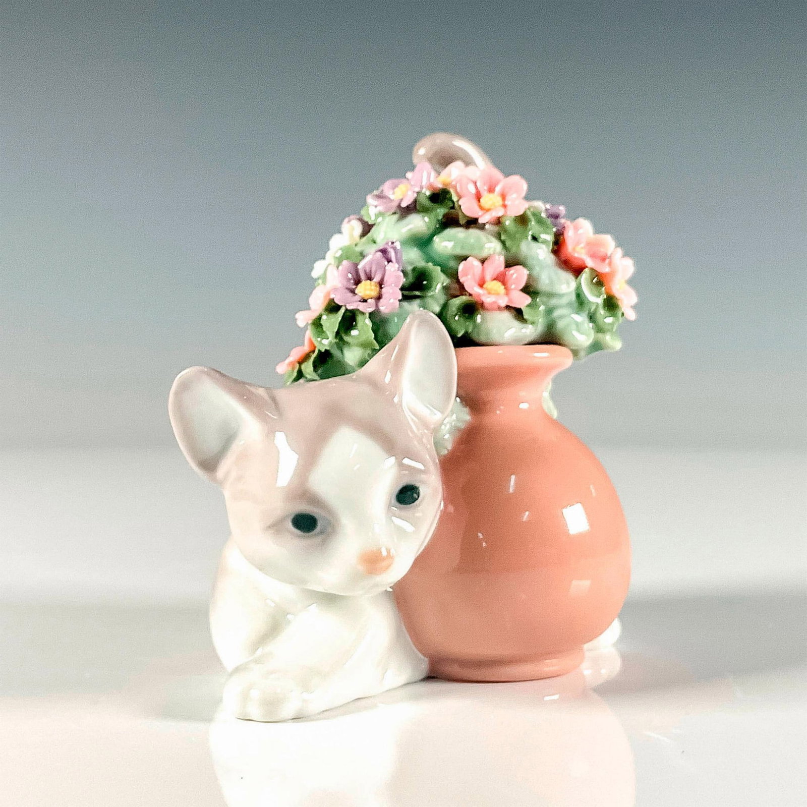 Secret Spot 1006566 - Lladro Porcelain Figurine: Glossy finish enchanting figure modeled as a kitty hiding behind a large delicate jardiniere of flowers. Lladro backstamp. Artist: Juan Huerta Issued: 1998-2004 Dimensions: 2.75"L x 4"W x 3.75"H Manuf