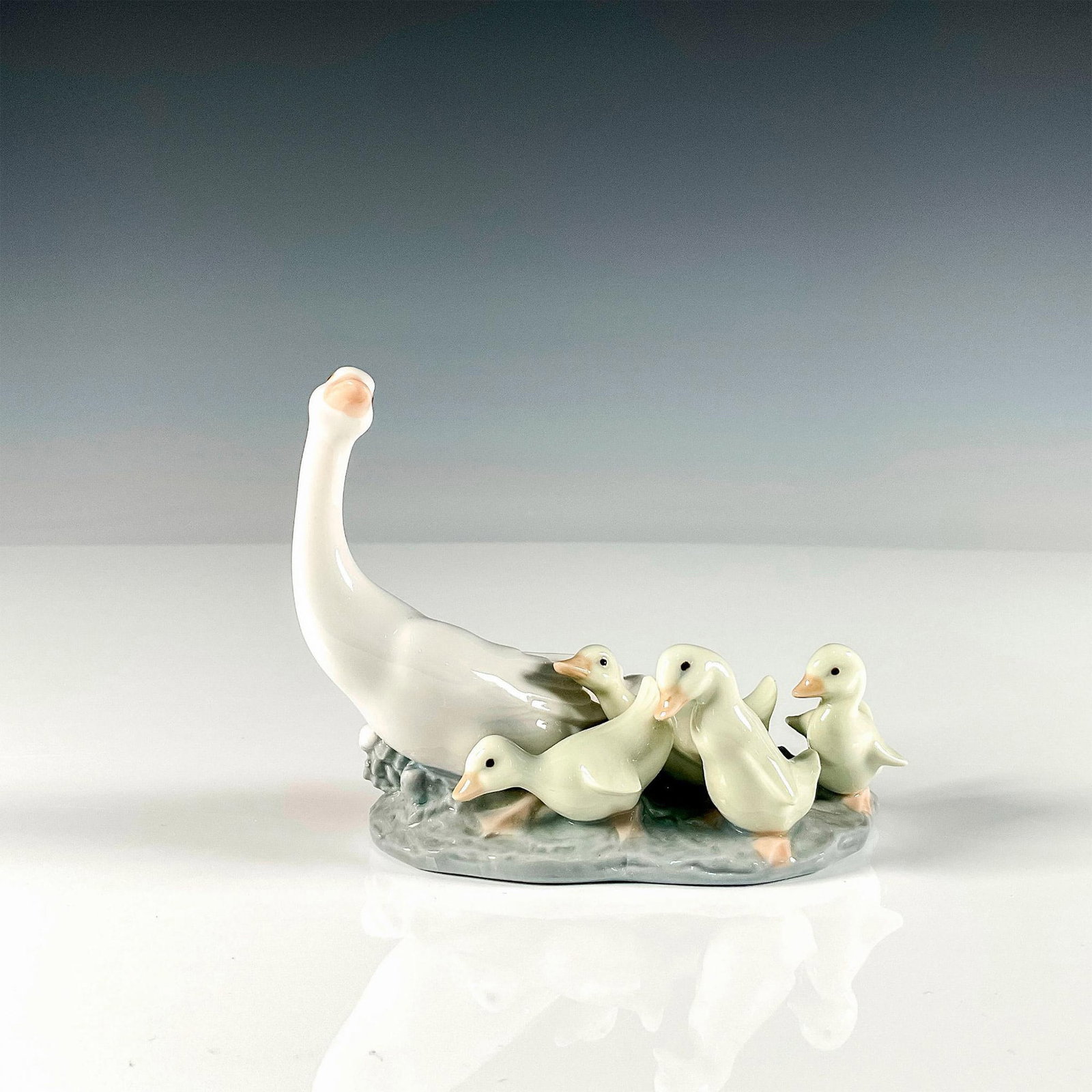 Ducklings 1001307 - Lladro Porcelain Figurine: Glossy finish depicting a mother duck and her four ducklings following behind. Lladro backstamp. Artist: Juan Huerta Issued: 1974-2017 Dimensions: 5"L x 2.5"W x 4"H Manufacturer: Lladro Country of Or