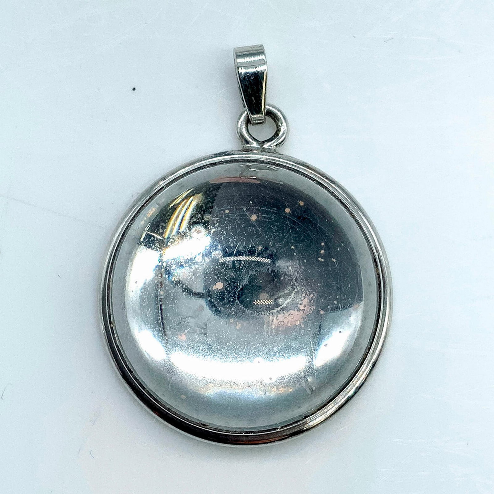 Lalique Sterling Silver Clear Cabochon Pendant: Sterling silver pendant with a clear cabochon. Dimensions: 1"dia. Manufacturer: Lalique Country of Origin: France Provenance: Collection of Marie-Claude Lalique