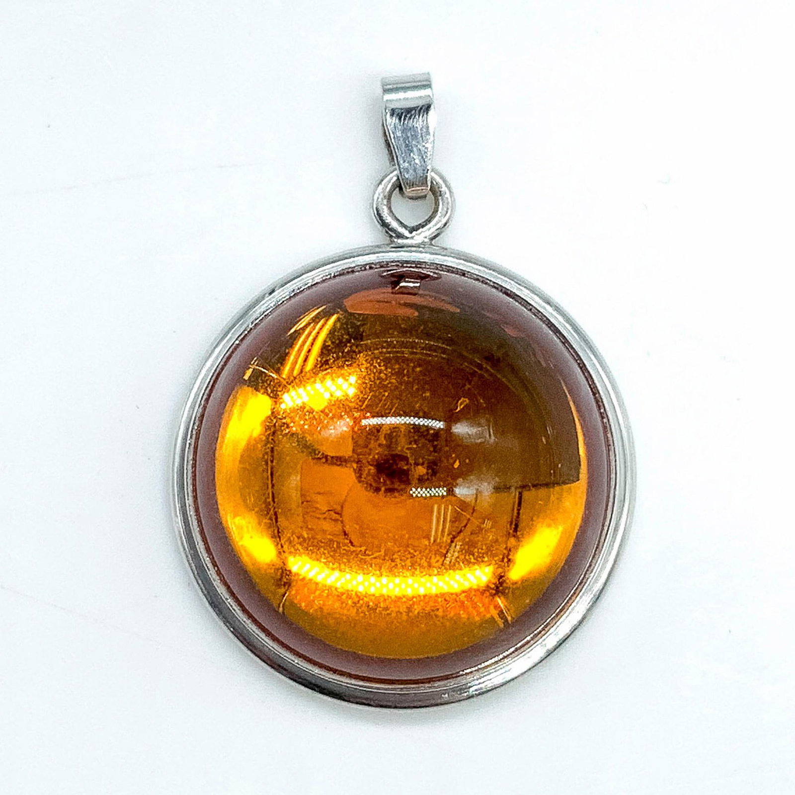 Lalique Sterling Silver Orange Cabochon Pendant: Sterling silver pendant with an orange tone cabochon. Dimensions: 1"dia. Manufacturer: Lalique Country of Origin: France Provenance: Marie-Claude Lalique private collection.