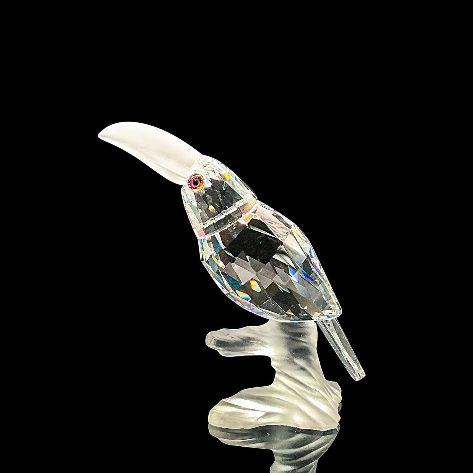 Swarovski Silver Crystal Figurine, Toucan: Clear faceted crystal figure of a toucan with blue/green/pink eyes frosted beak, perched on a frosted crystal base. Part of the Up in the Trees collection. Swarovski mark. Item number 7621NR000002. Th