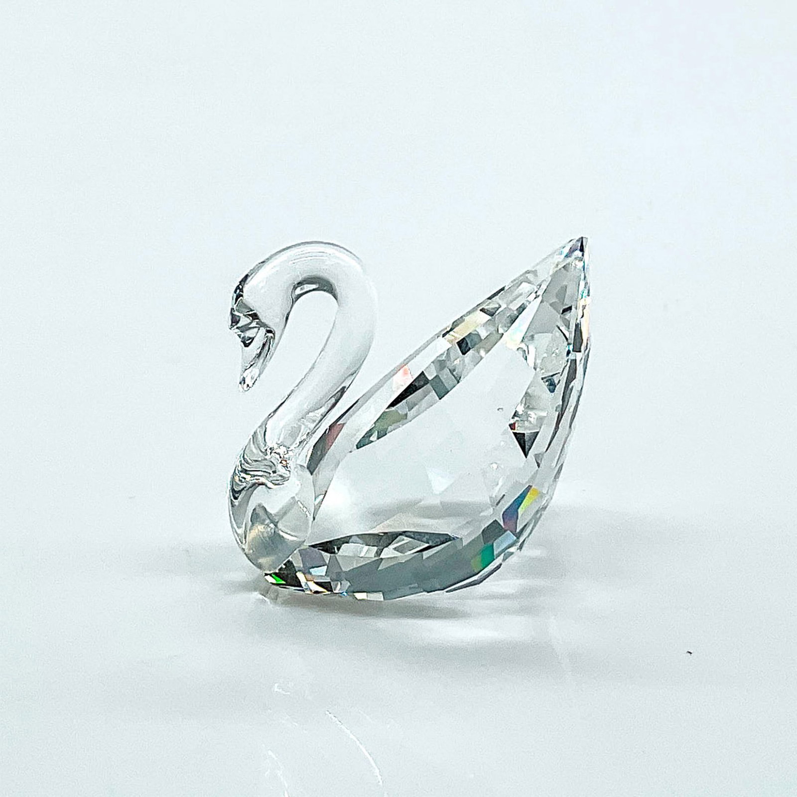 Swarovski Crystal Figurine, Mini Swan: Multifaceted clear crystal swan. Swarovski etched backstamp. This item has its original box: 2.25"H x 2.5"dia and shipping box. Issued: 20th century Dimensions: 1.25"L x 0.75"W x 1.25"H Manufacturer: 