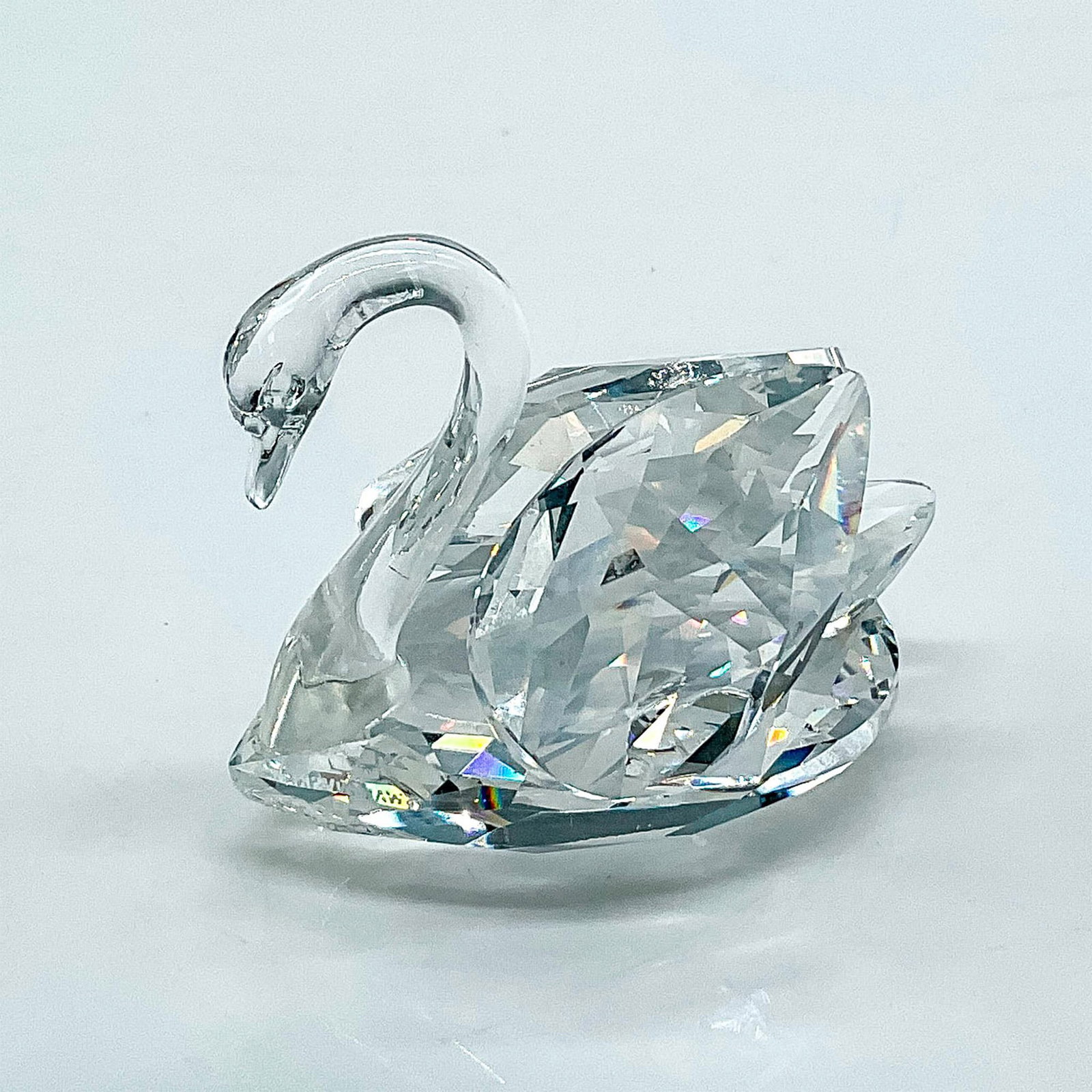 Swarovski Silver Crystal Figurine, Swan: Multifaceted clear crystal swan. Swarovski etched backstamp. This item has its original box: 3.75"H x 3.25"dia. Issued: 20th century Dimensions: 2"L x 1.25"W x 1.75"H Manufacturer: Swarovski Country o