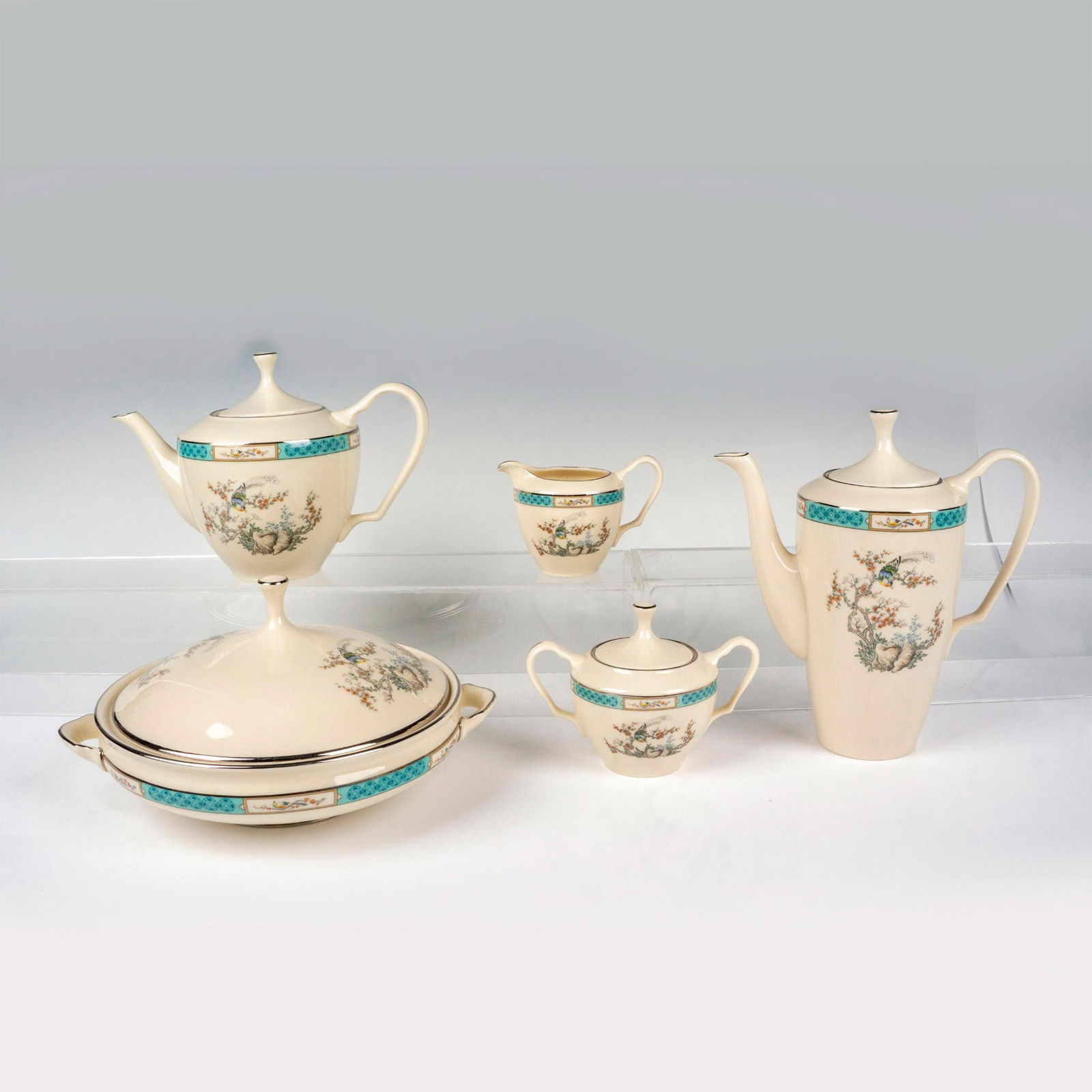 5pc Lenox Teapot, Coffee Pot, Serveware, Plum Blossoms: Off white porcelain tableware serving items with pleasant image of bird perched in a plum blossom tree; silver rims and accents. Lenox backstamp. Teapot 9.75"L x 5.25"W x 7"H. Coffee pot 8.75"L x 4.25