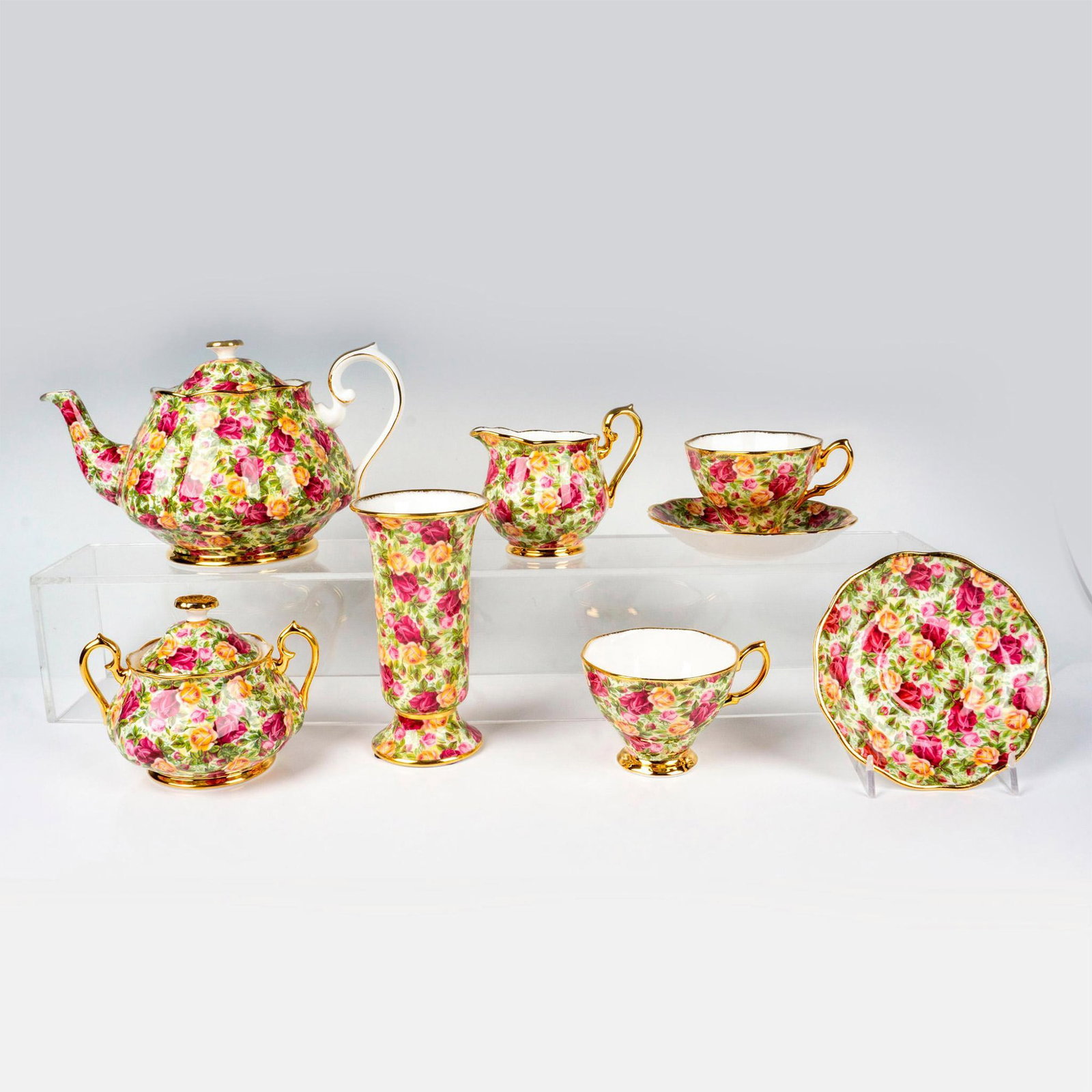 8pc Royal Albert Tea Set, Old Country Roses: Bone china tea set in a magenta, gold and pink roses design, gold rims and handles. Royal Albert backstamp. Teapot 10"L x 5.75"W x 6"H. Flower vase 6"H x 3.25" dia. Sugar bowl 5.5"L x 4.25"W x 4.25"H.