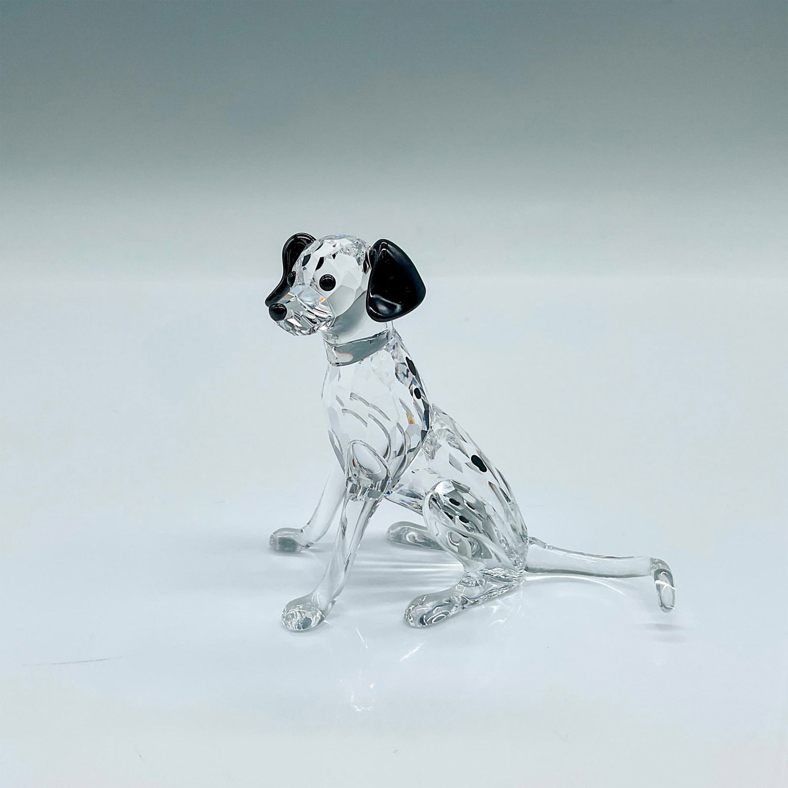 Swarovski Crystal Figurine, Dalmatian Mother: Part of The Peaceful Countryside collection. A clear crystal puppy with black ears, eyes, nose, and spots. Swarovski marked. This item has its original box: 6"L x 6"W x 3.75"H. Artist: Edith Mair Issu